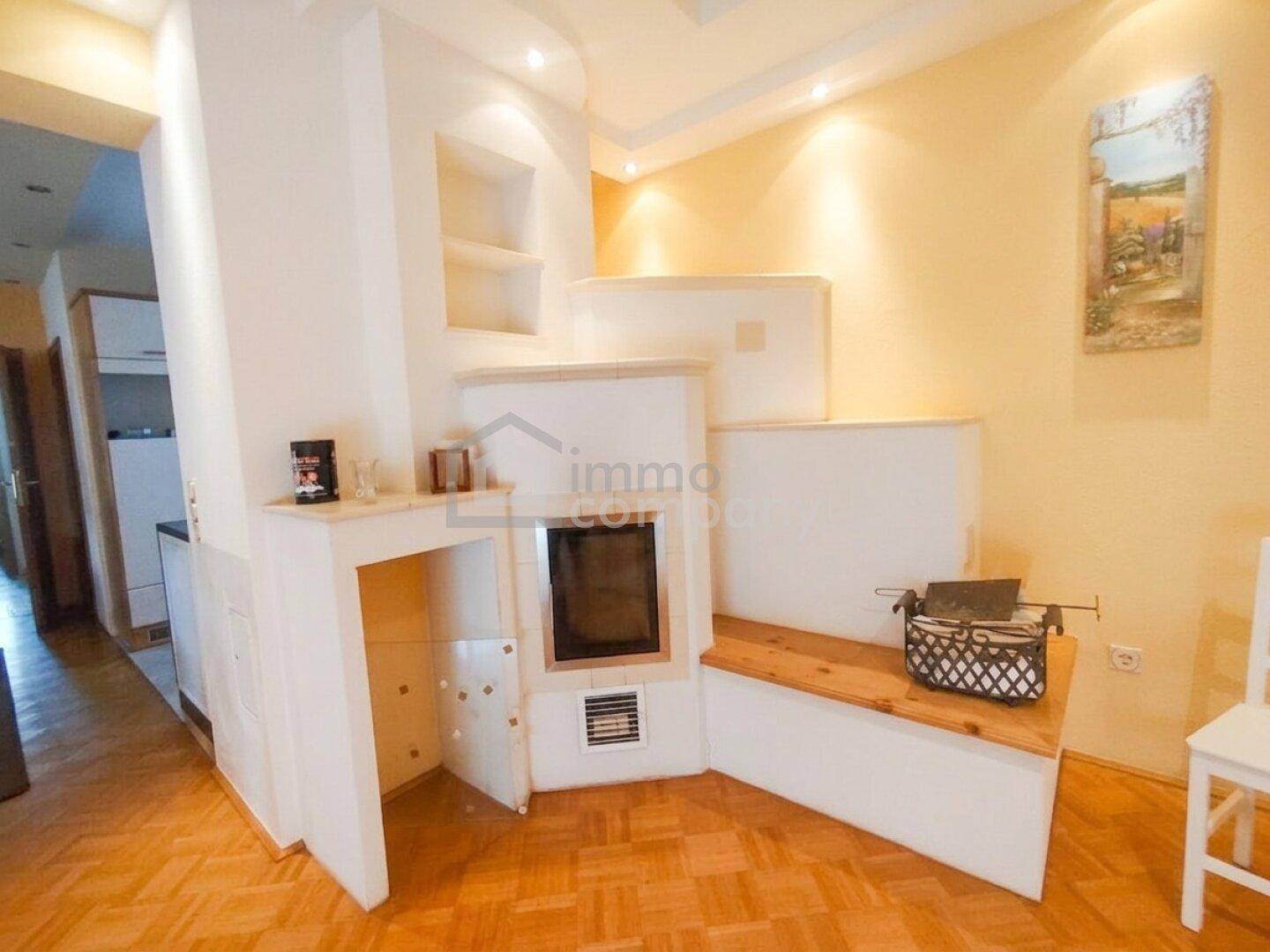 Detailansicht des traditionellen Kachelofens mit integrierter Sitzbank im Wohnbereich, ideal zum Entspannen.