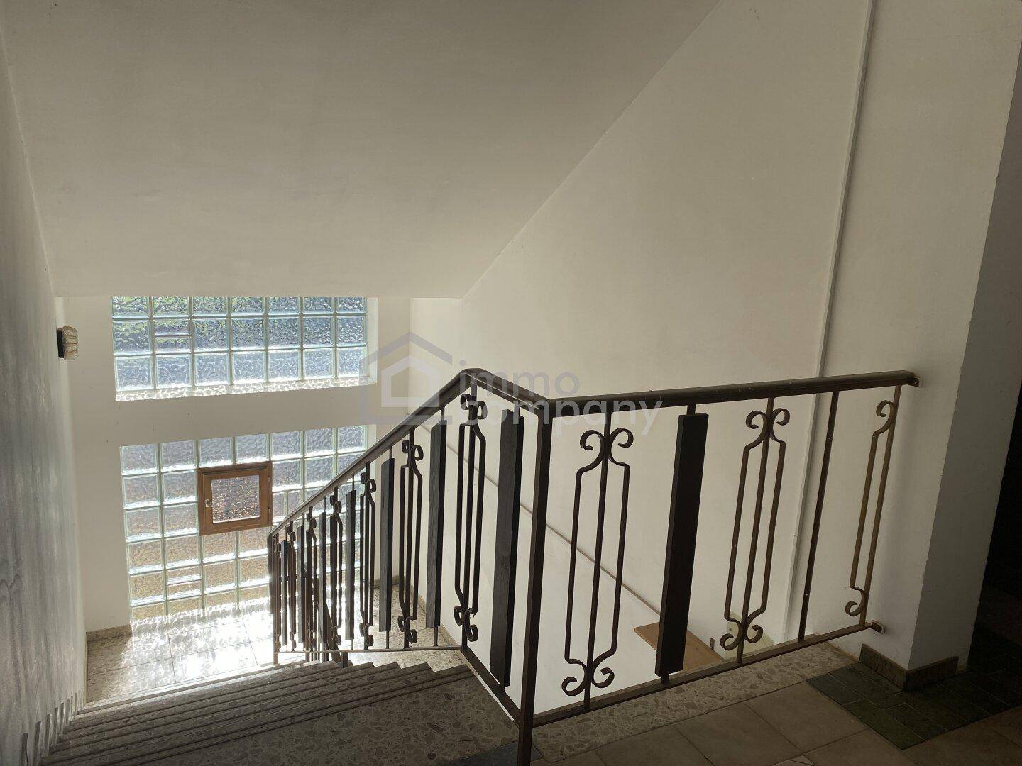 Helles Treppenhaus mit Glasbausteinen, die natürliches Licht hereinlassen und ein offenes Gefühl vermitteln.