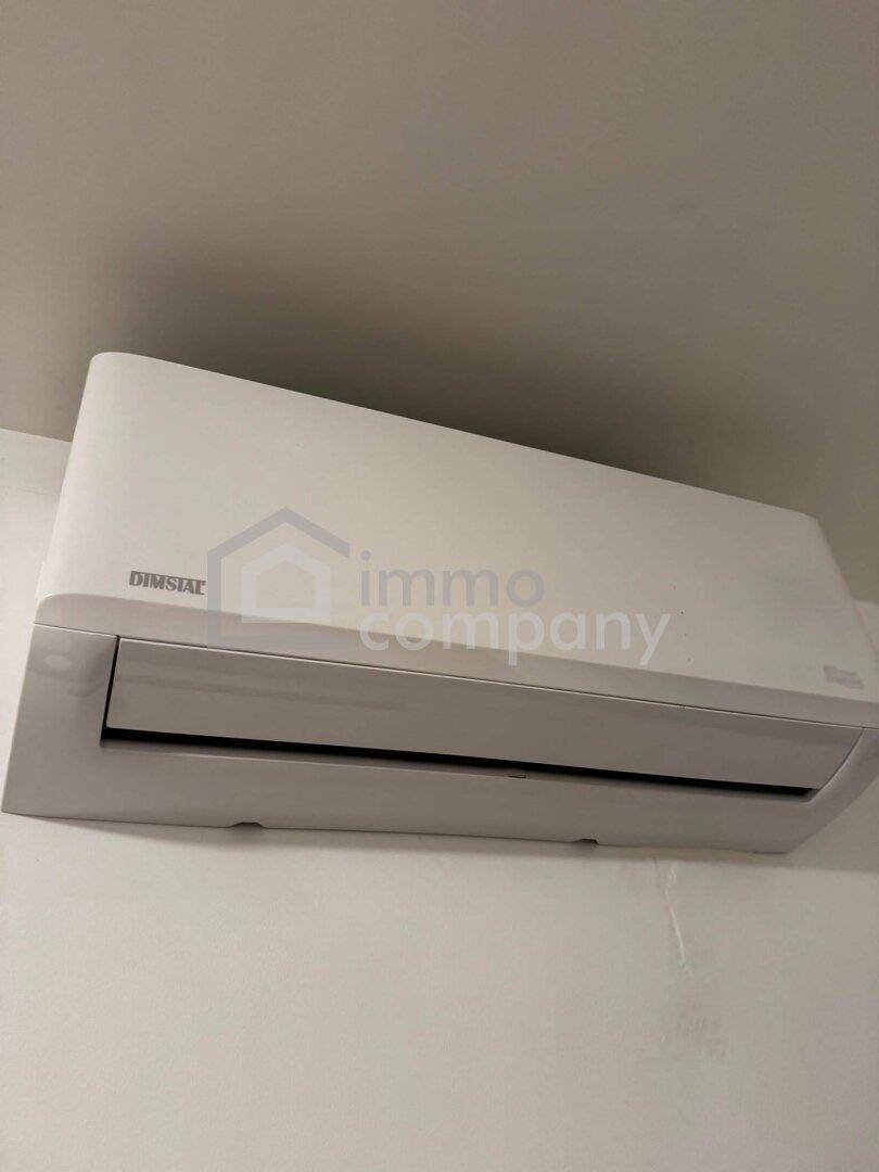 Nahaufnahme einer modernen Klimaanlage an einer weißen Wand.