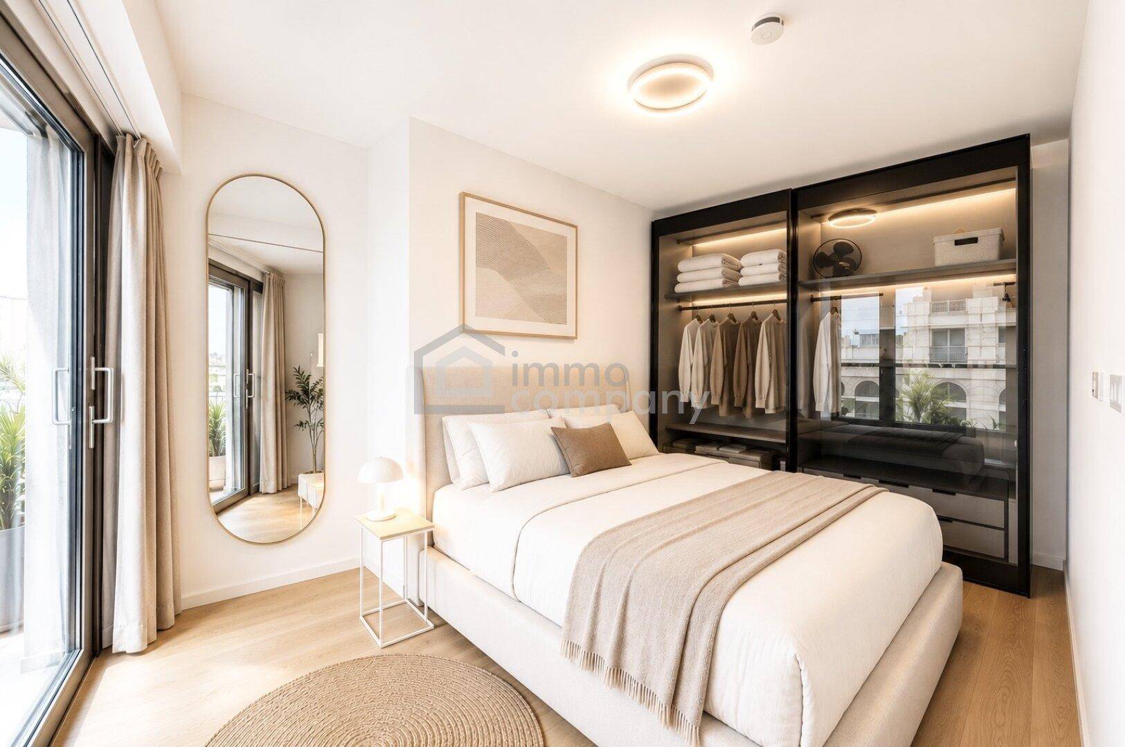 Helles Schlafzimmer mit modernem Bett, integriertem Kleiderschrank und Zugang zum Balkon.