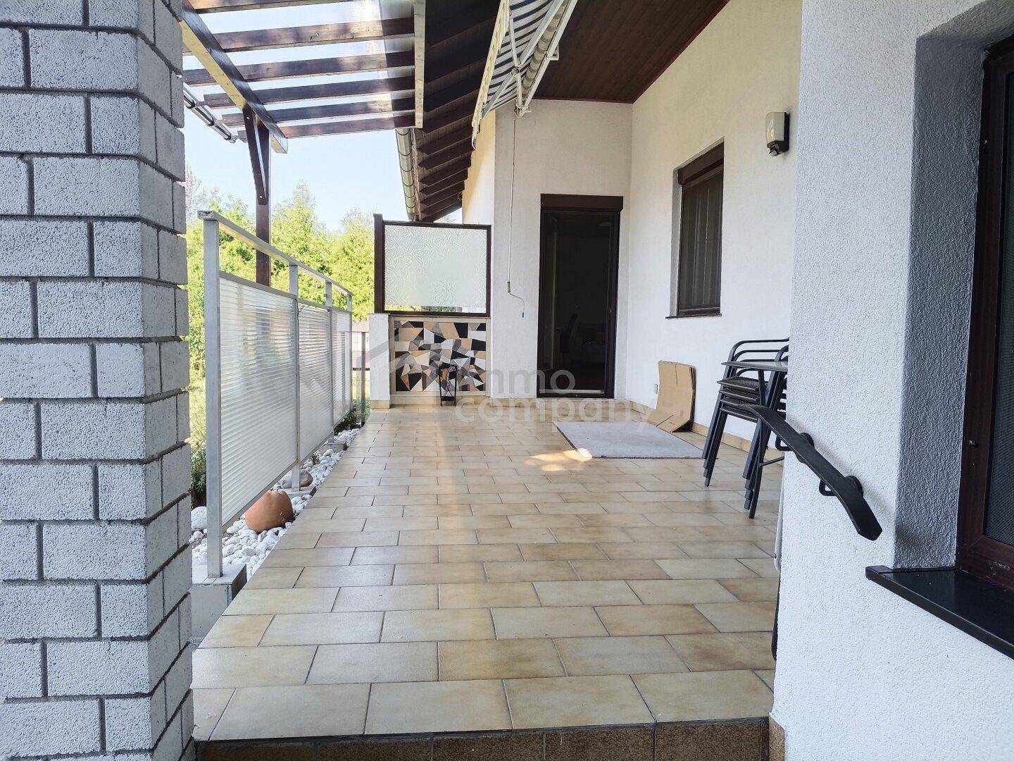 Geflieste Terrasse mit Pergola und seitlichem Sichtschutz, ideal für entspannte Stunden im Freien.