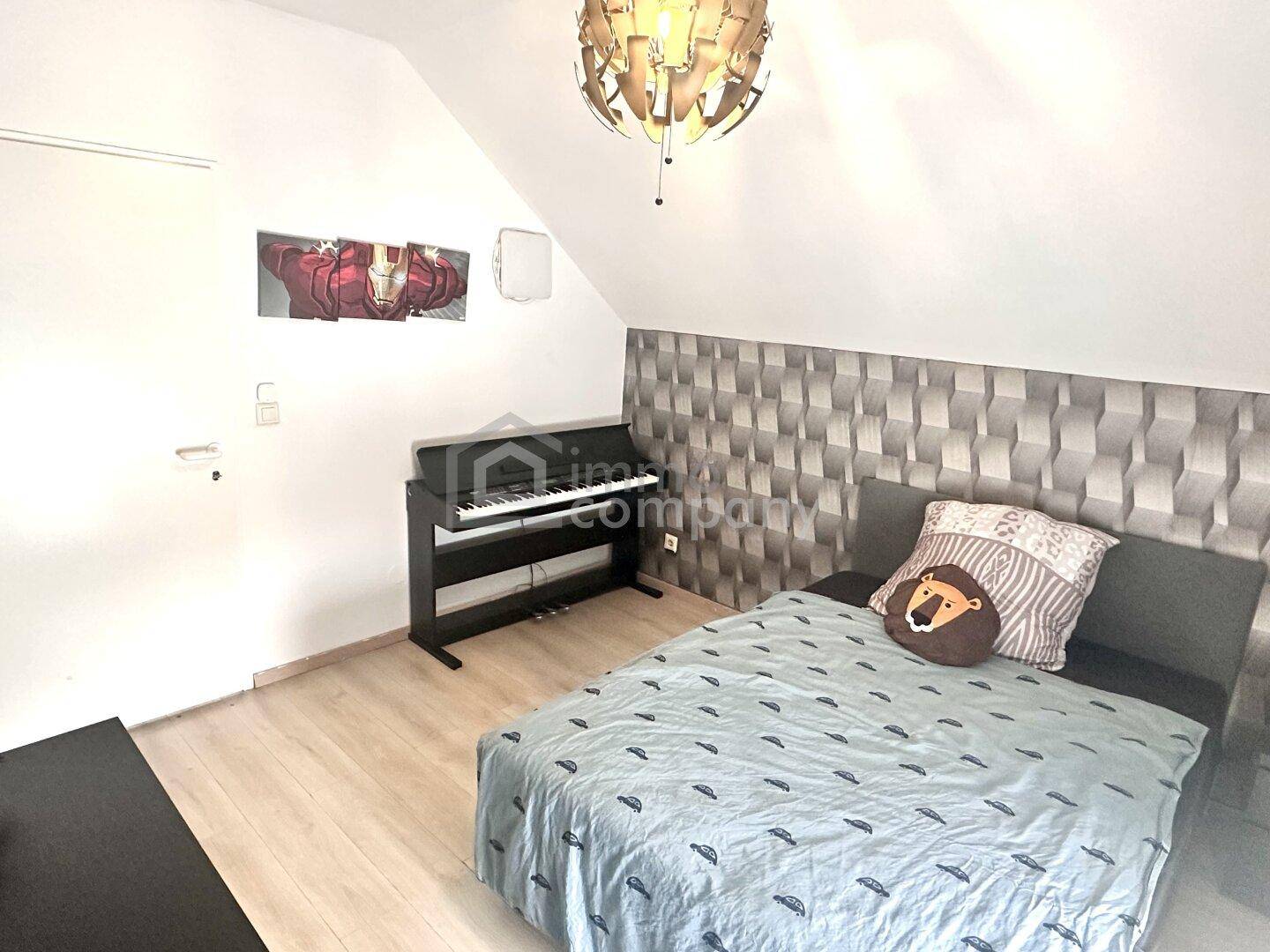 Gemütliches Schlafzimmer mit Dachschräge, Doppelbett und modernem Dekor.