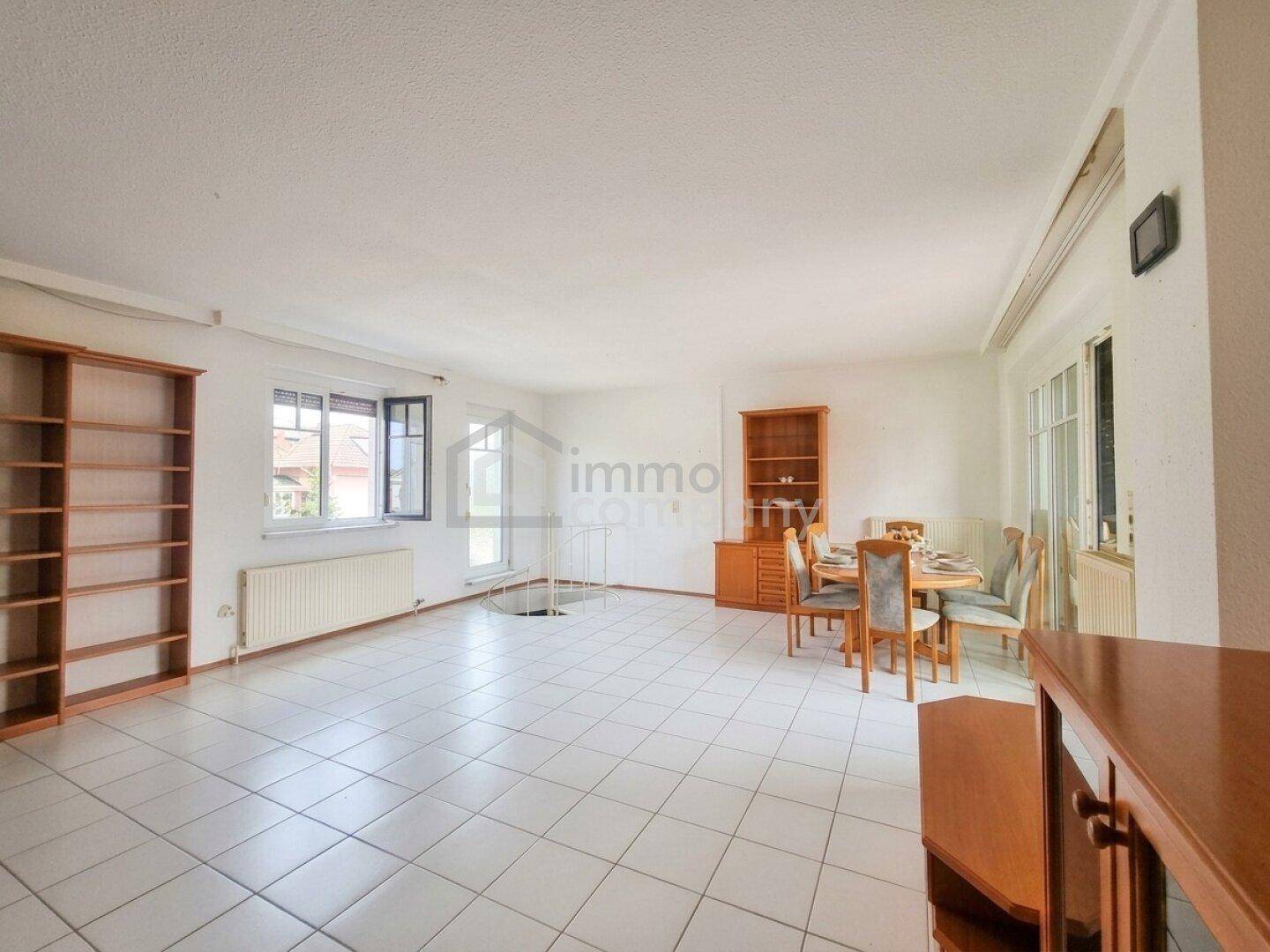Heller Wohn-Essbereich mit großen Fenstern, Fliesenboden und viel Platz für individuelle Gestaltung.