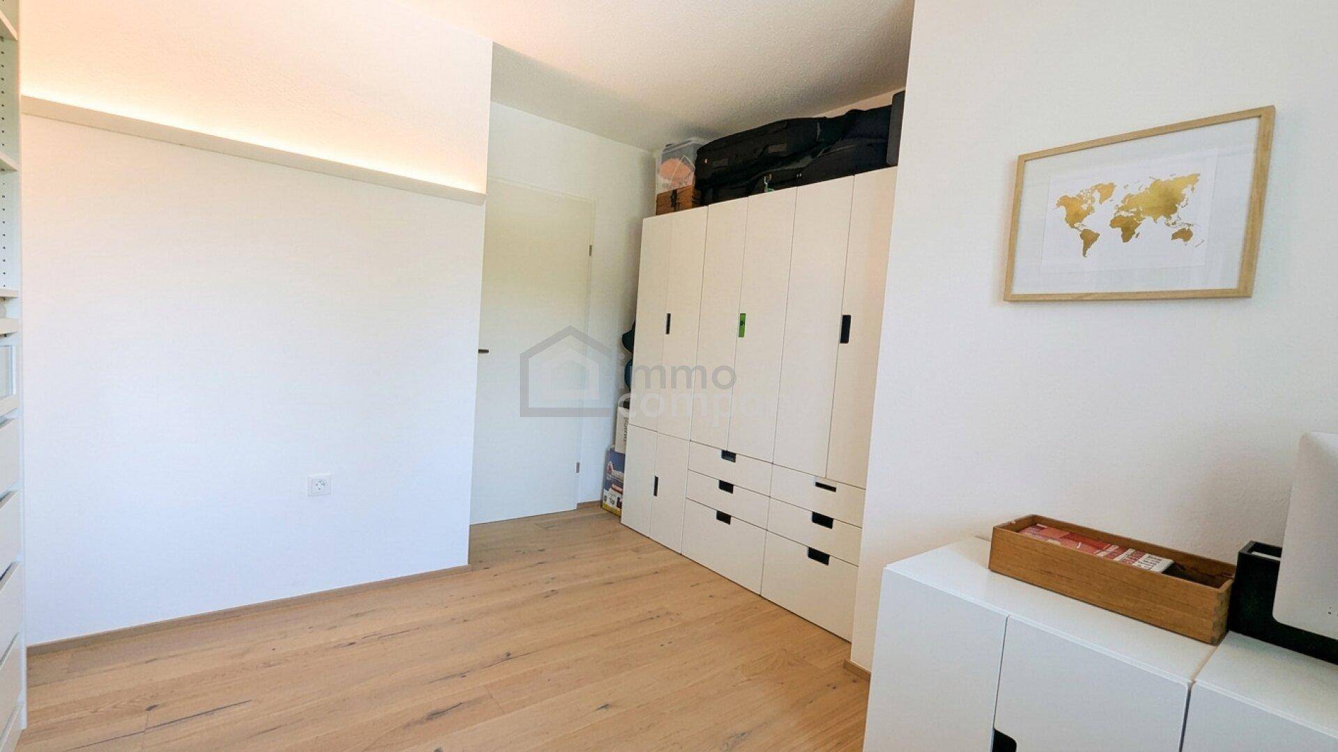 Heller Ankleidebereich mit Einbauschränken und Holzboden, bietet viel Platz für Kleidung.