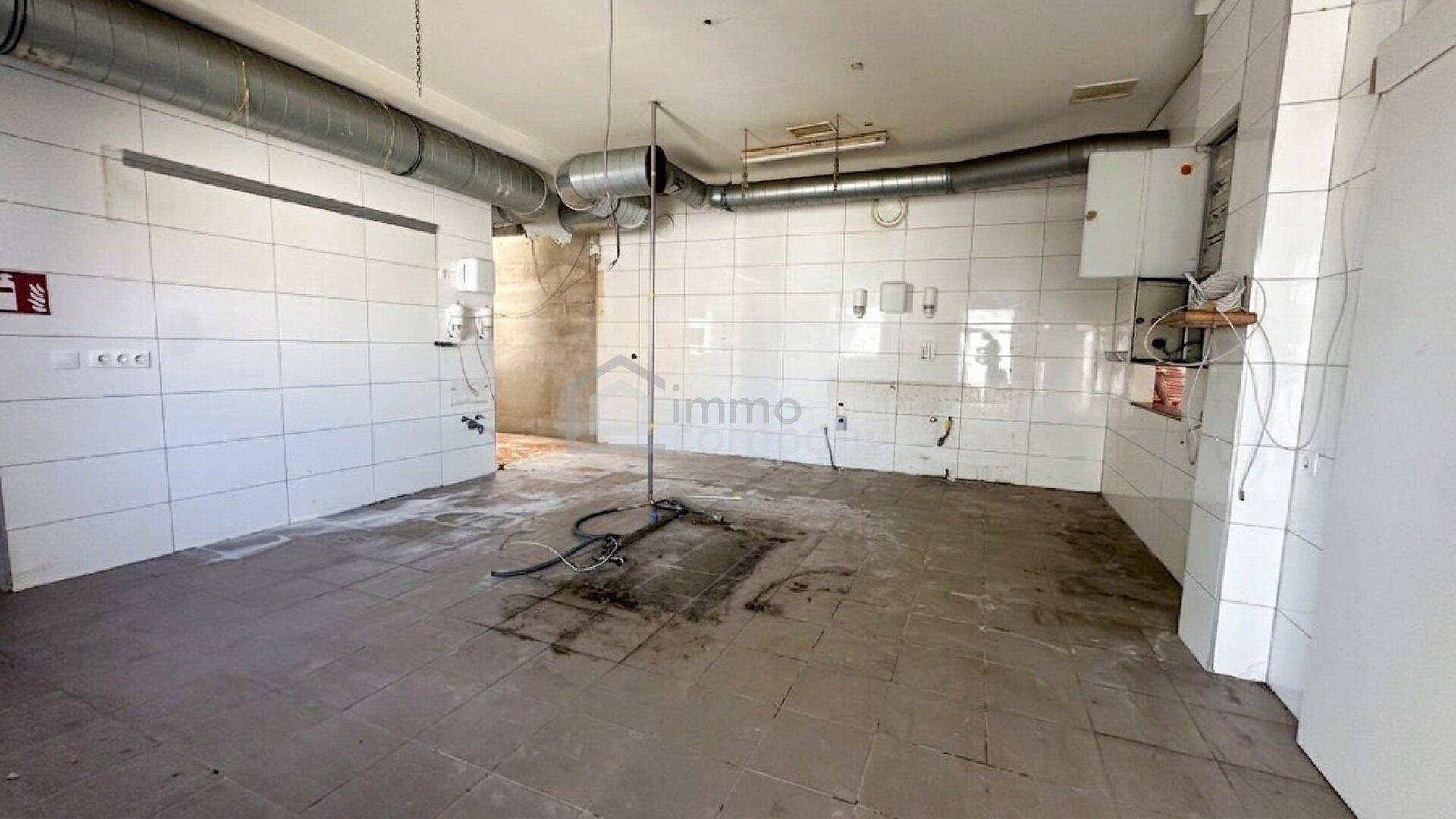 Gefliester Raum mit sichtbaren Rohren und Anschlüssen, bereit für den Ausbau.