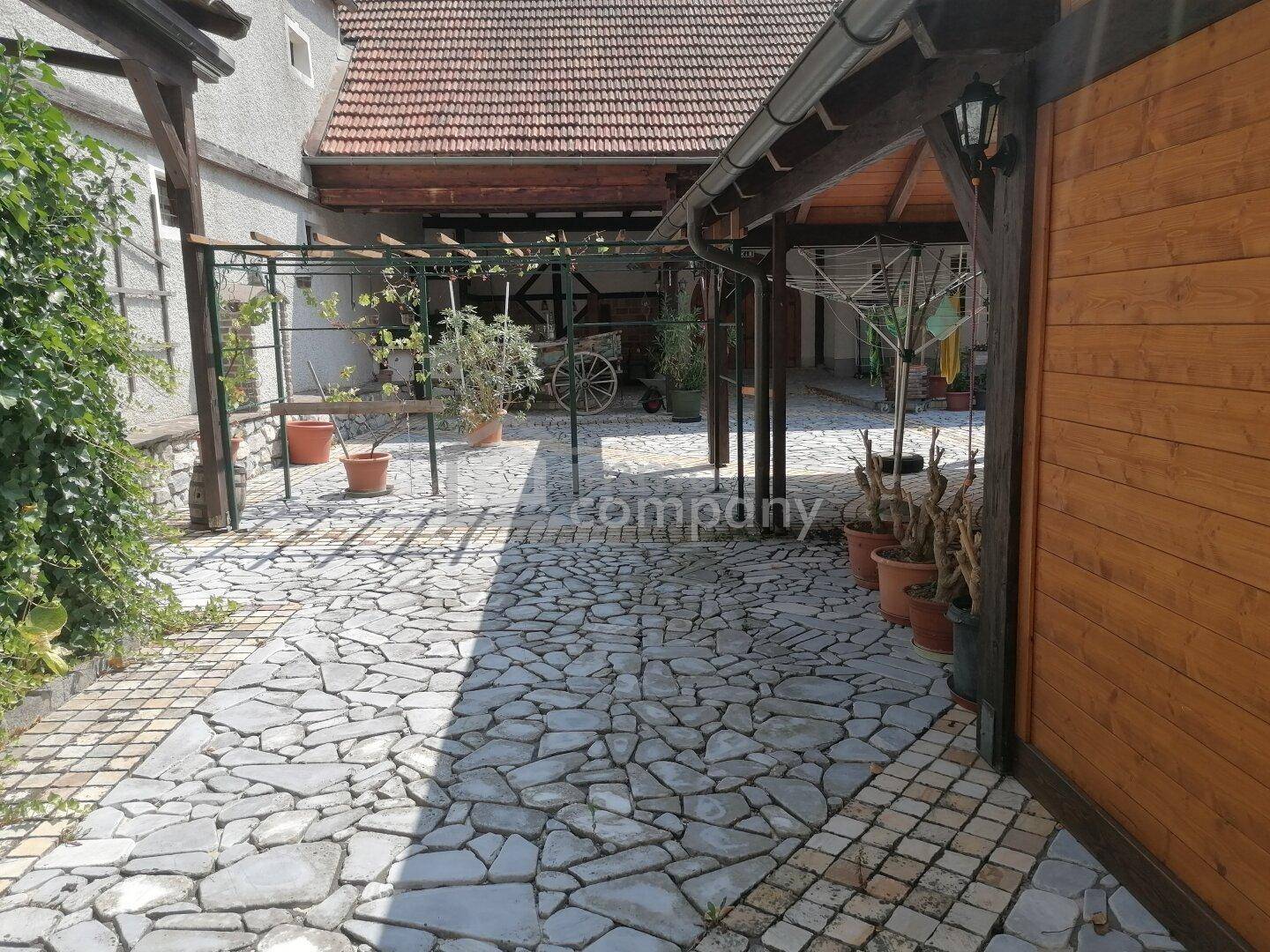 Gepflasterter Innenhof mit Pergola und Topfpflanzen, bietet einen charmanten Außenbereich.