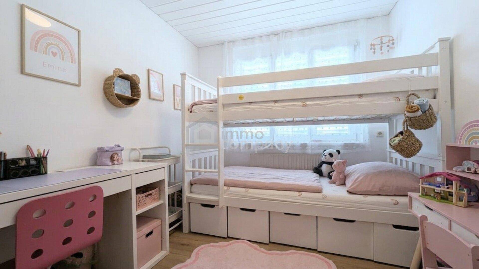 Helles Kinderzimmer mit weißem Etagenbett, Schreibtisch und freundlicher, farbenfroher Dekoration.