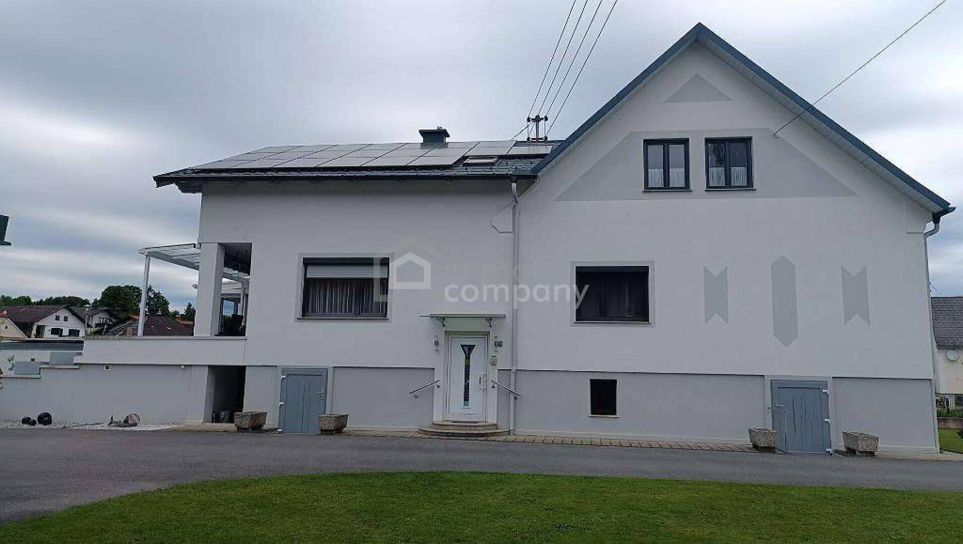 Vorderansicht des Einfamilienhauses mit Eingangsbereich, Solaranlage und gepflegtem Vorgarten.