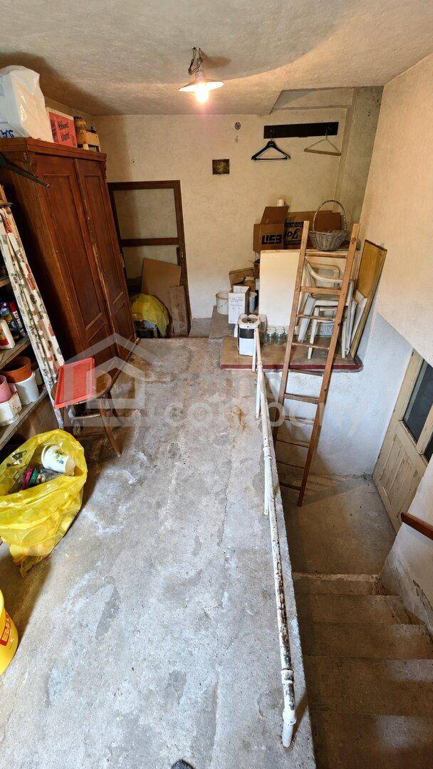 Treppenhaus mit Lagerbereich auf dem Podest, das in einen unteren Bereich führt.