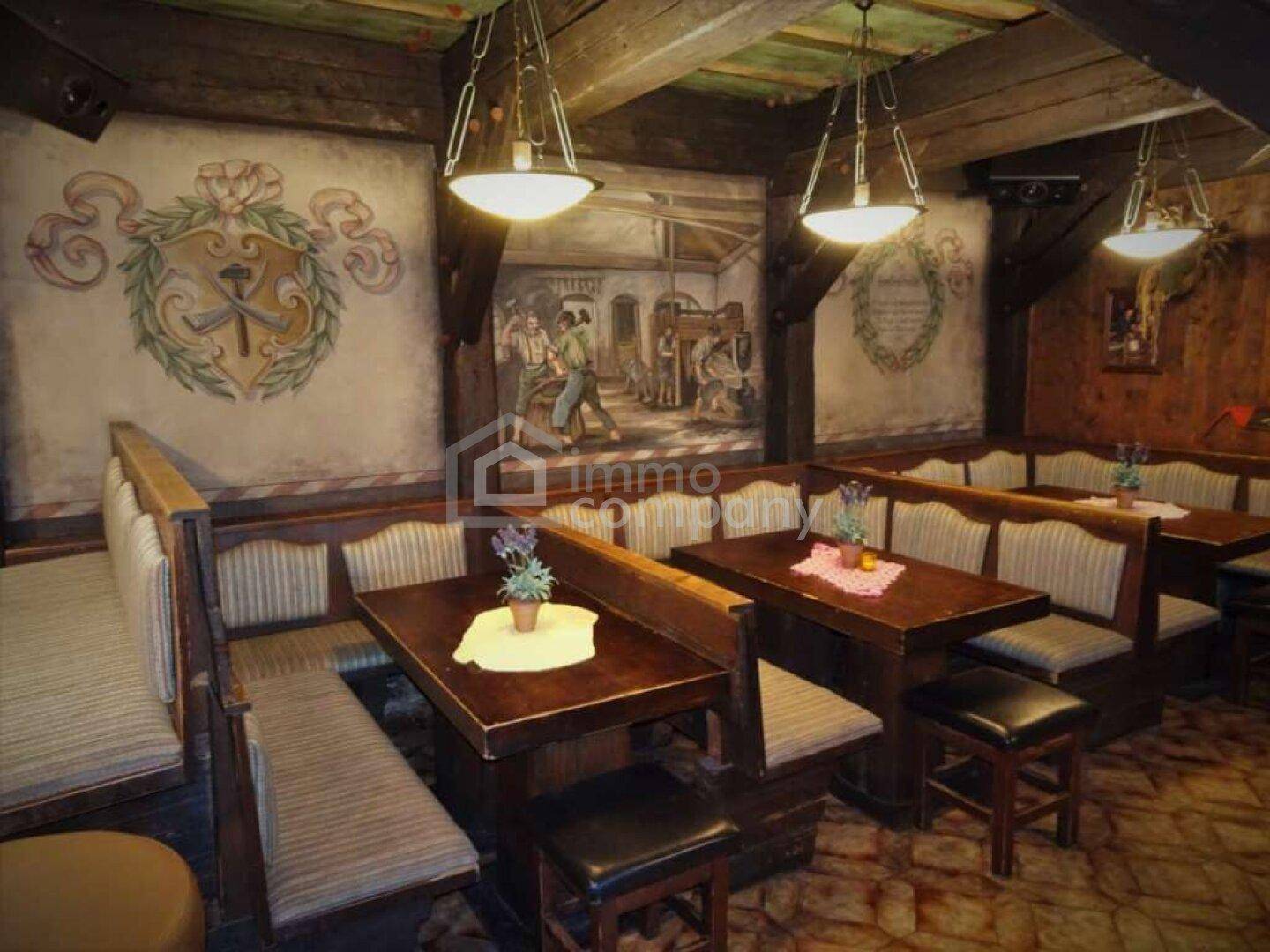 Gemütlicher Speisesaal im traditionellen alpenländischen Stil mit Holzbänken und Wandmalereien.