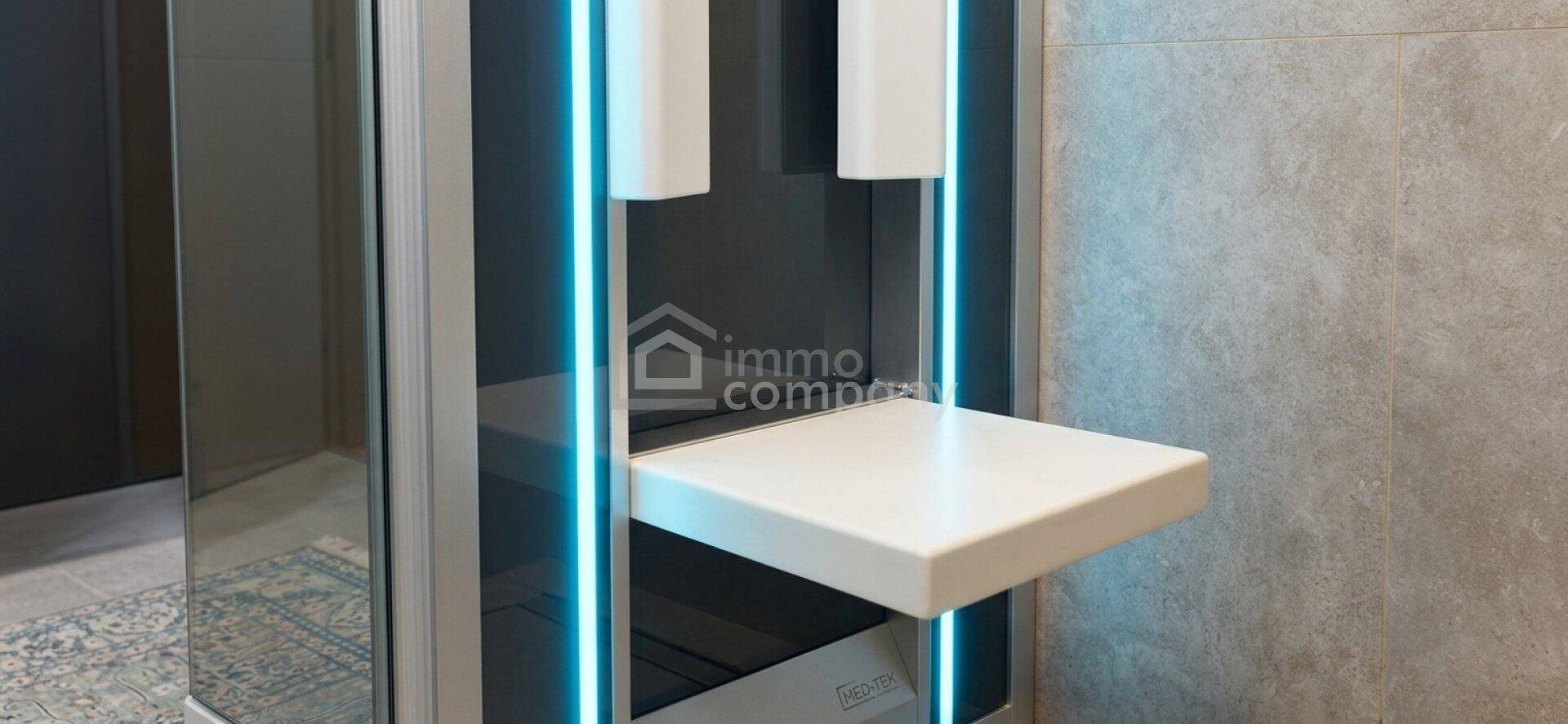 Detailansicht einer modernen Dusche mit blauer LED-Beleuchtung und Ablagefläche.