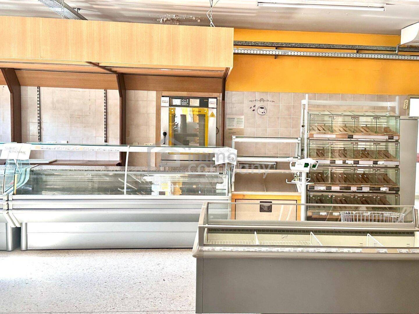 Bereich mit Verkaufstheken, Backofen und Auslagen in einem ehemaligen Lebensmittelgeschäft oder Bäckerei.