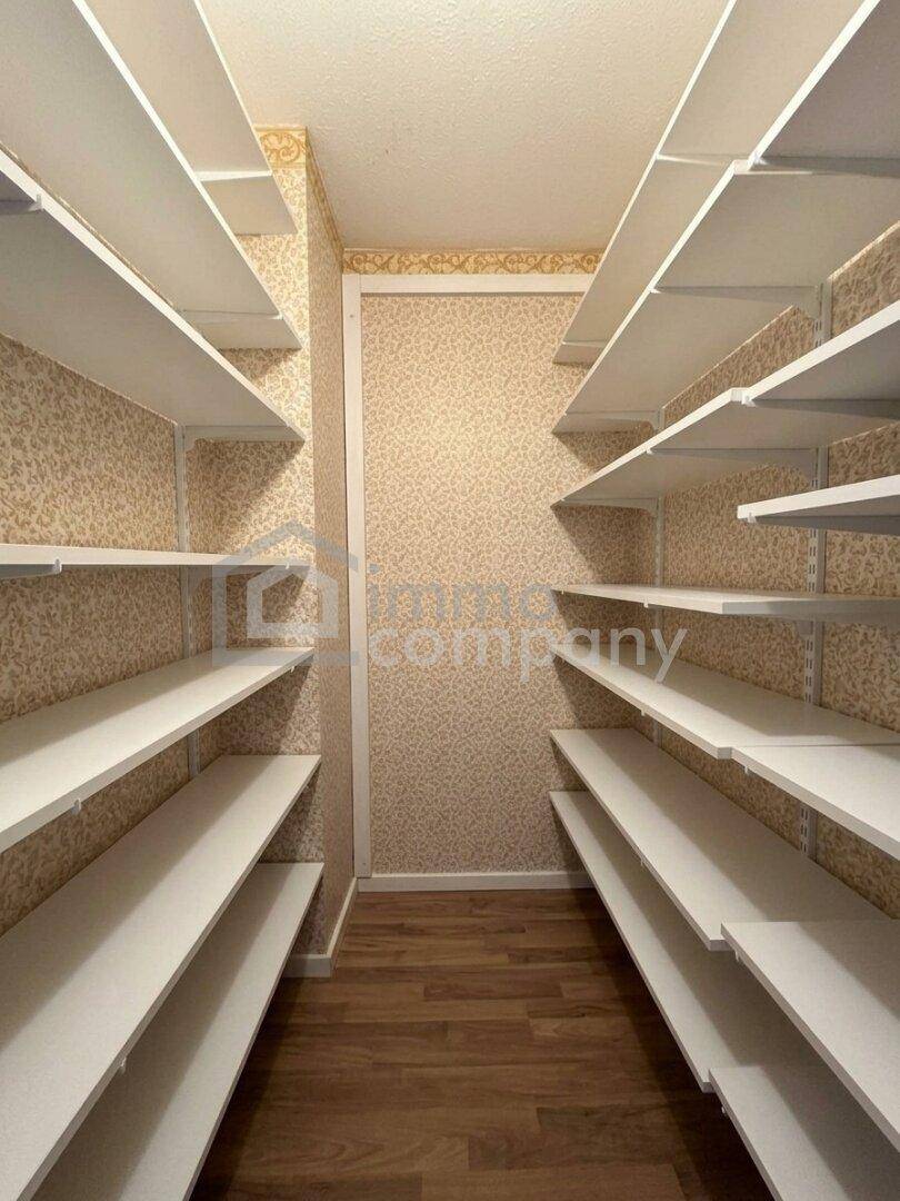 Begehbarer Kleiderschrank mit vielen Regalen und Stauraum, ideal für Organisation.