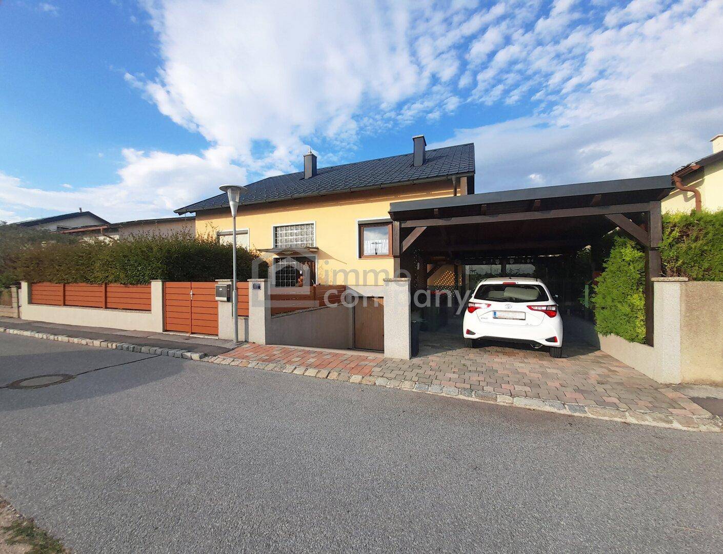 Vorderansicht des Hauses mit Carport und gepflegtem Eingangsbereich von der Straße aus.