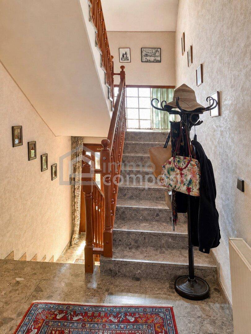 Heller Flur mit Steintreppe, Fliesenboden und Garderobe, führt in die oberen Etagen.