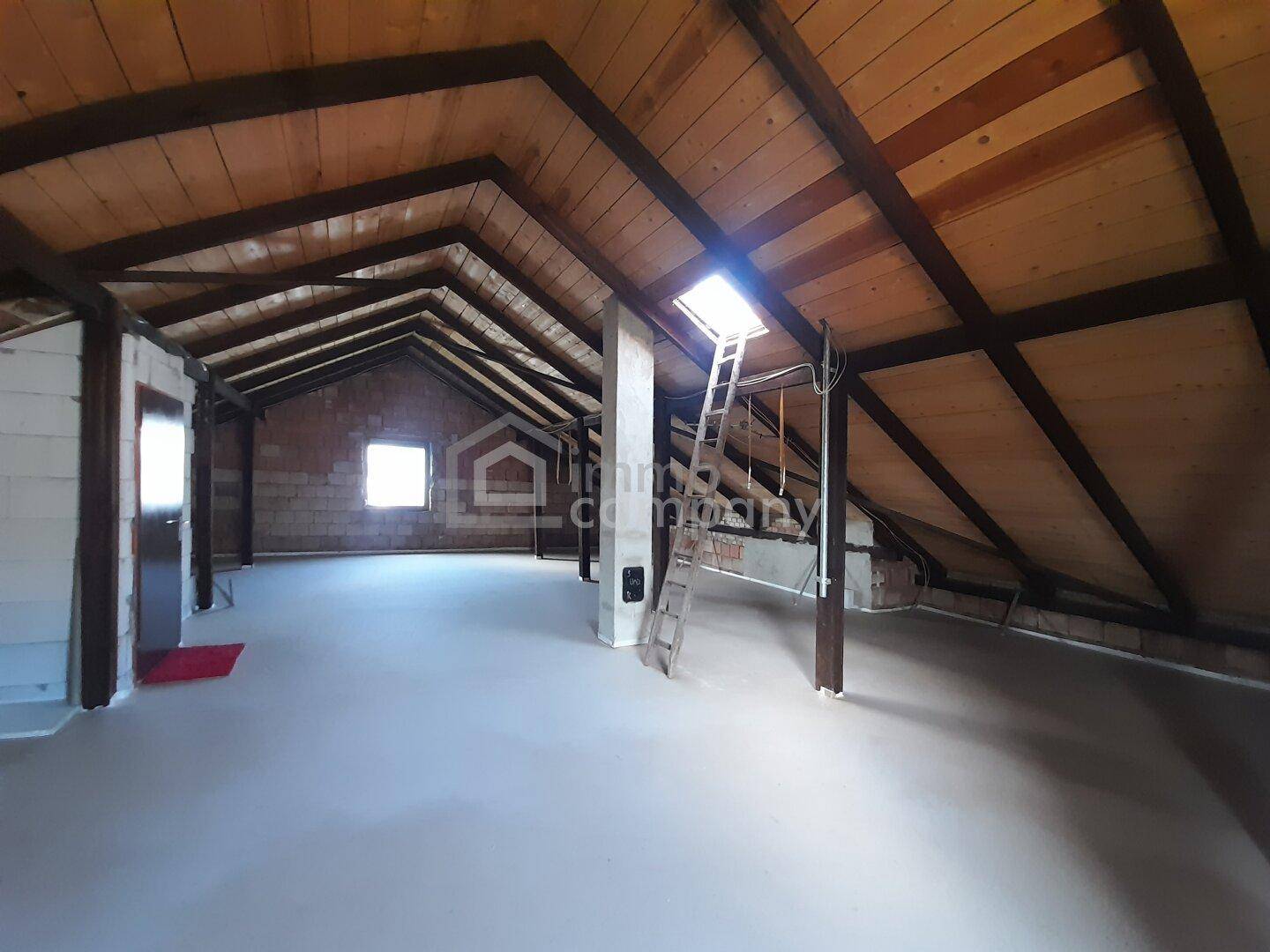 Geräumiger Dachboden mit sichtbaren Holzbalken und Dachfenster, bietet Ausbaupotenzial.