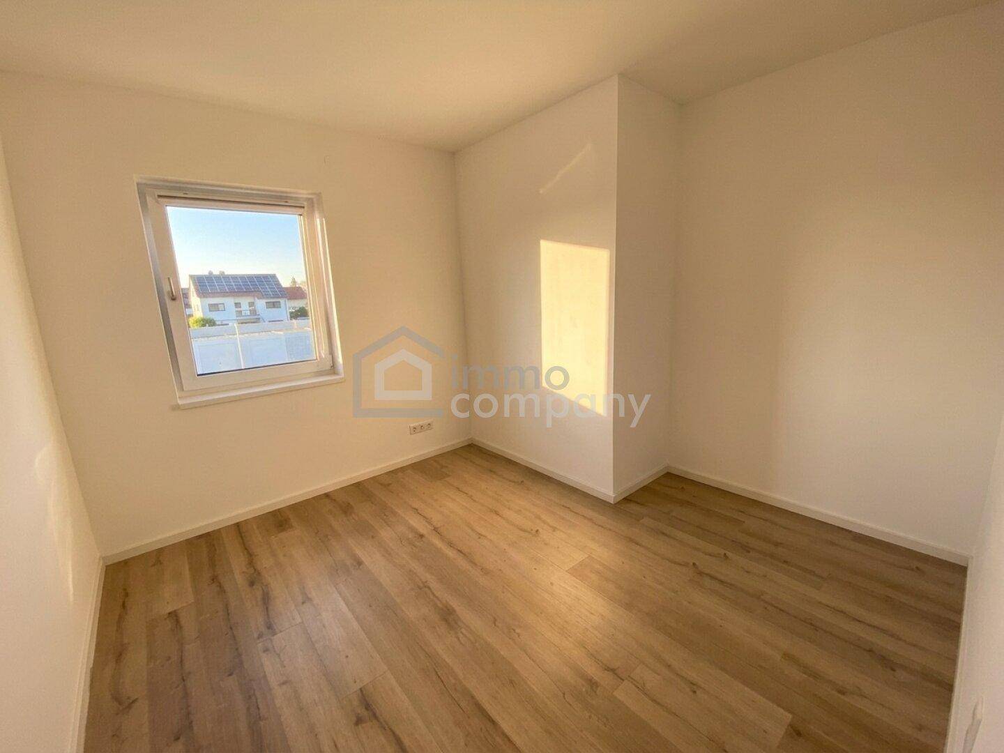 Kleines, helles Zimmer mit Holzboden und Fenster, ideal als Kinder- oder Gästezimmer.