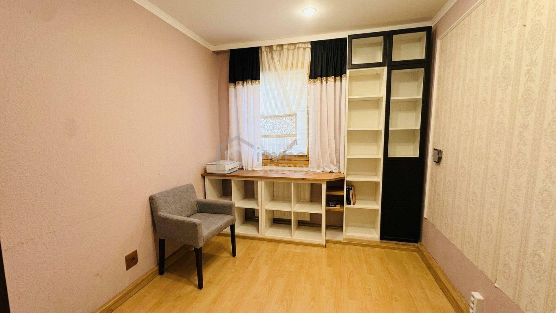 Helles Zimmer mit Laminatboden, Fenster und integrierten Regalen, ideal als Büro oder Gästezimmer.