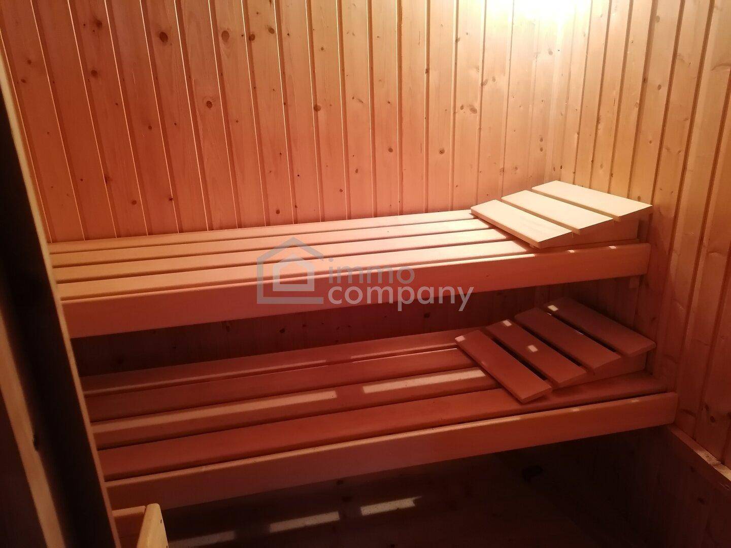 Holzvertäfelte Sauna mit Sitzbänken, ideal zur Entspannung und Erholung.