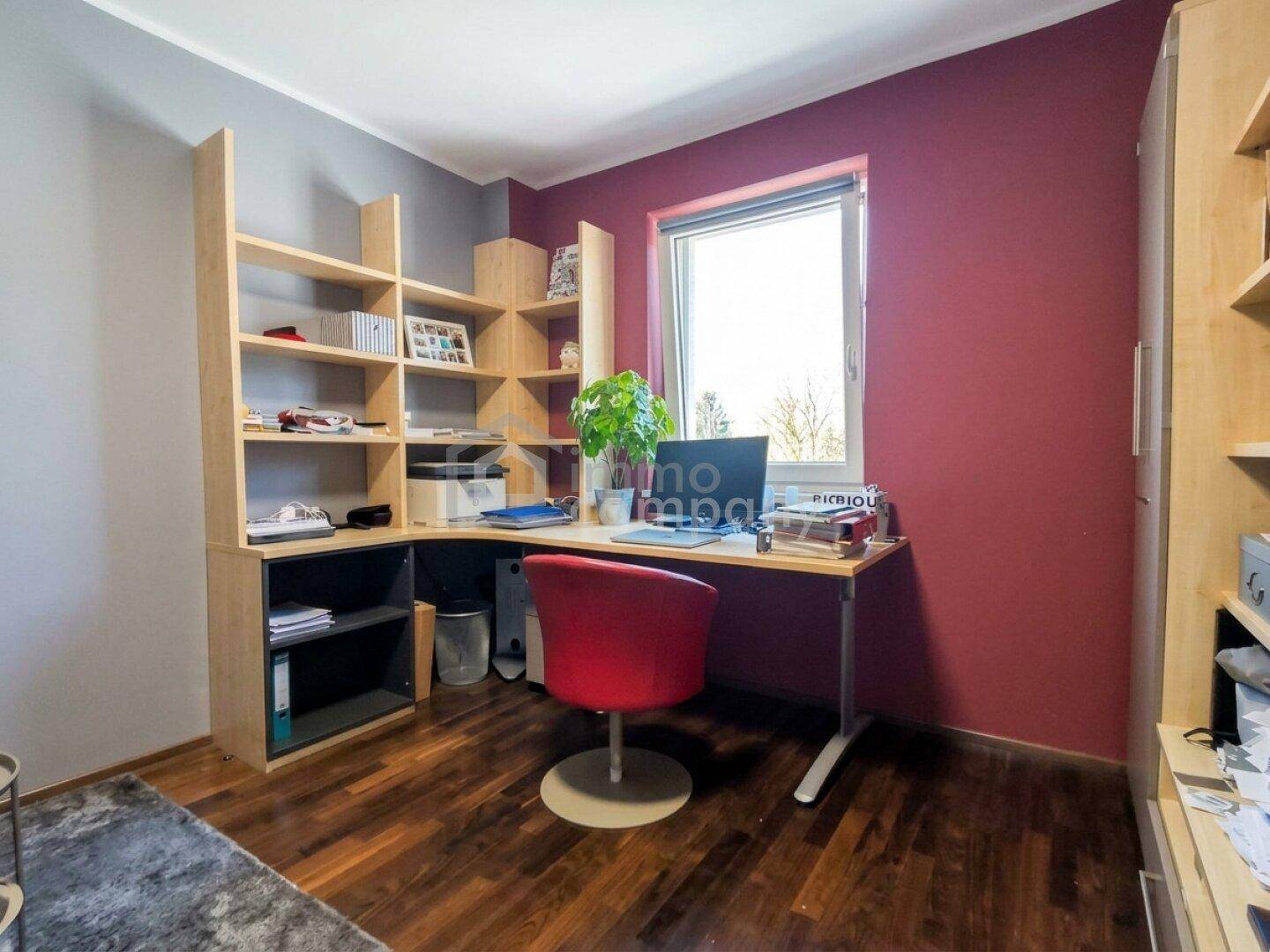 Funktionales Arbeitszimmer mit Eckschreibtisch, Regalen und farbigen Wänden.