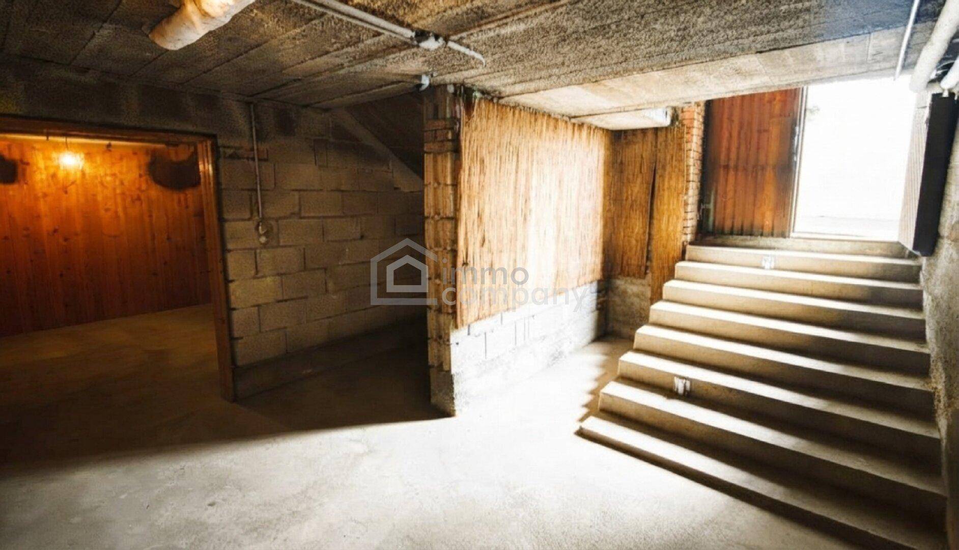 Unausgebauter Kellerbereich mit Betonboden und Treppe, die nach oben führt.