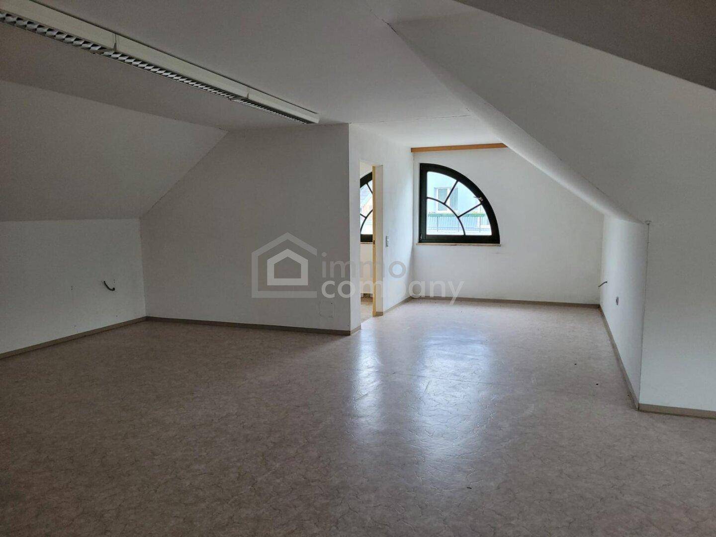 Heller Dachbodenraum mit Schrägen, Linoleumboden und Bogenfenster, bietet viel Tageslicht.