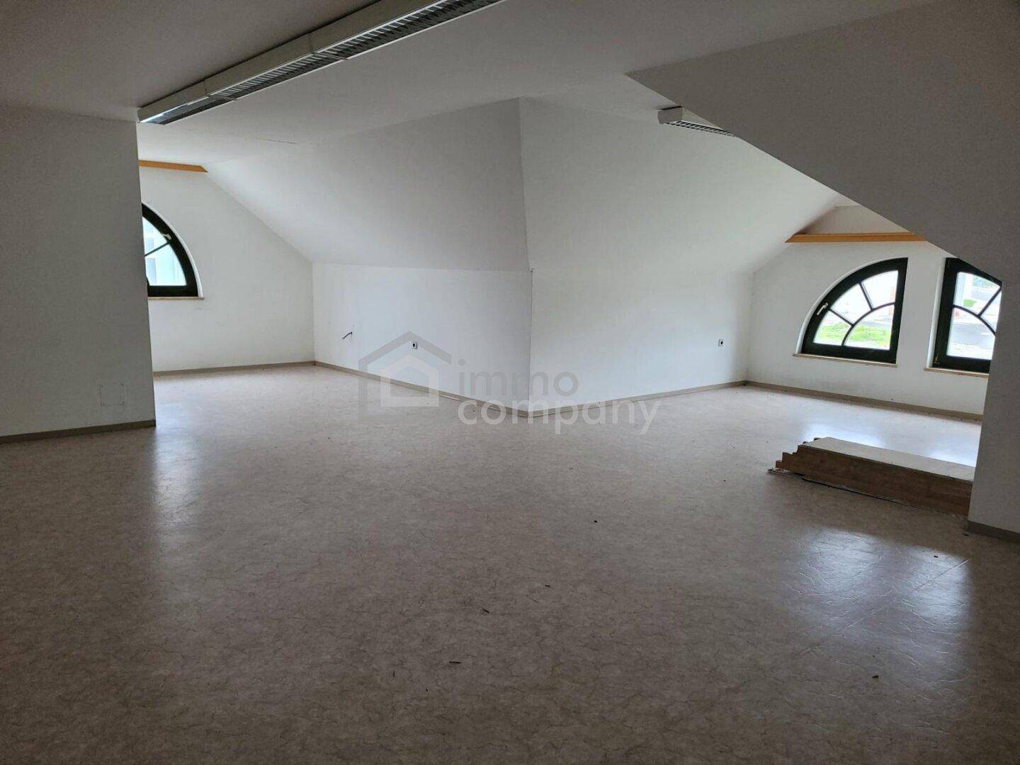 Großer Dachbodenraum mit mehreren Bogenfenstern und Linoleumboden, vielseitig nutzbar.