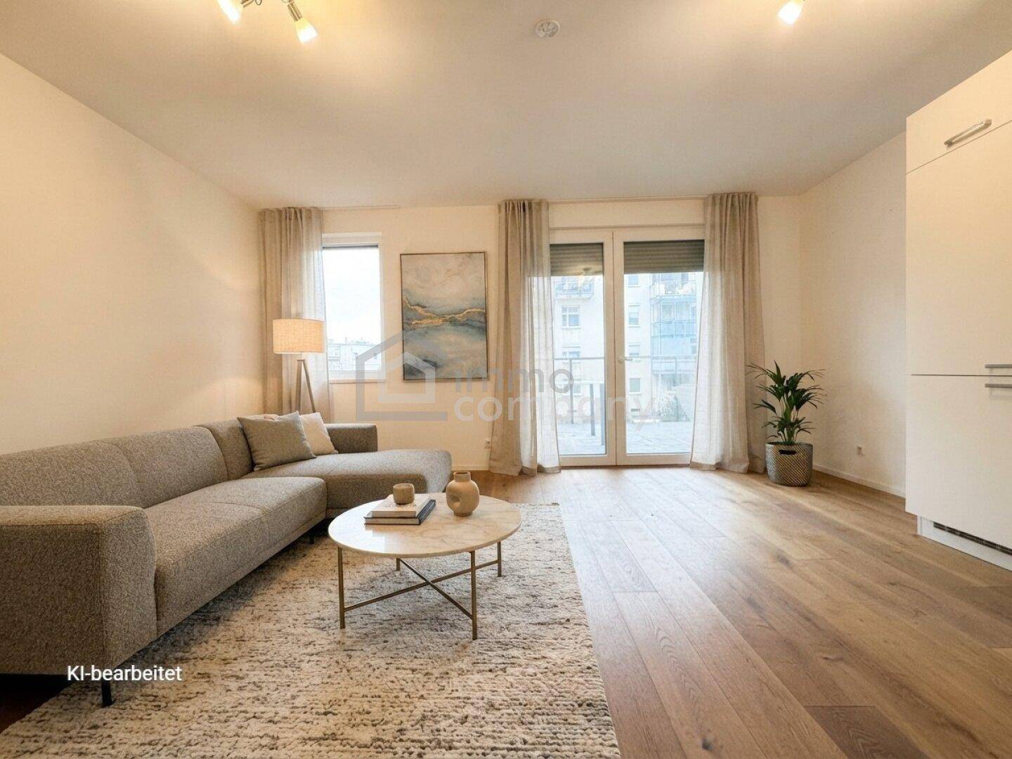 Helles Wohnzimmer mit modernem Sofa, Holzboden und Zugang zu einem Balkon.