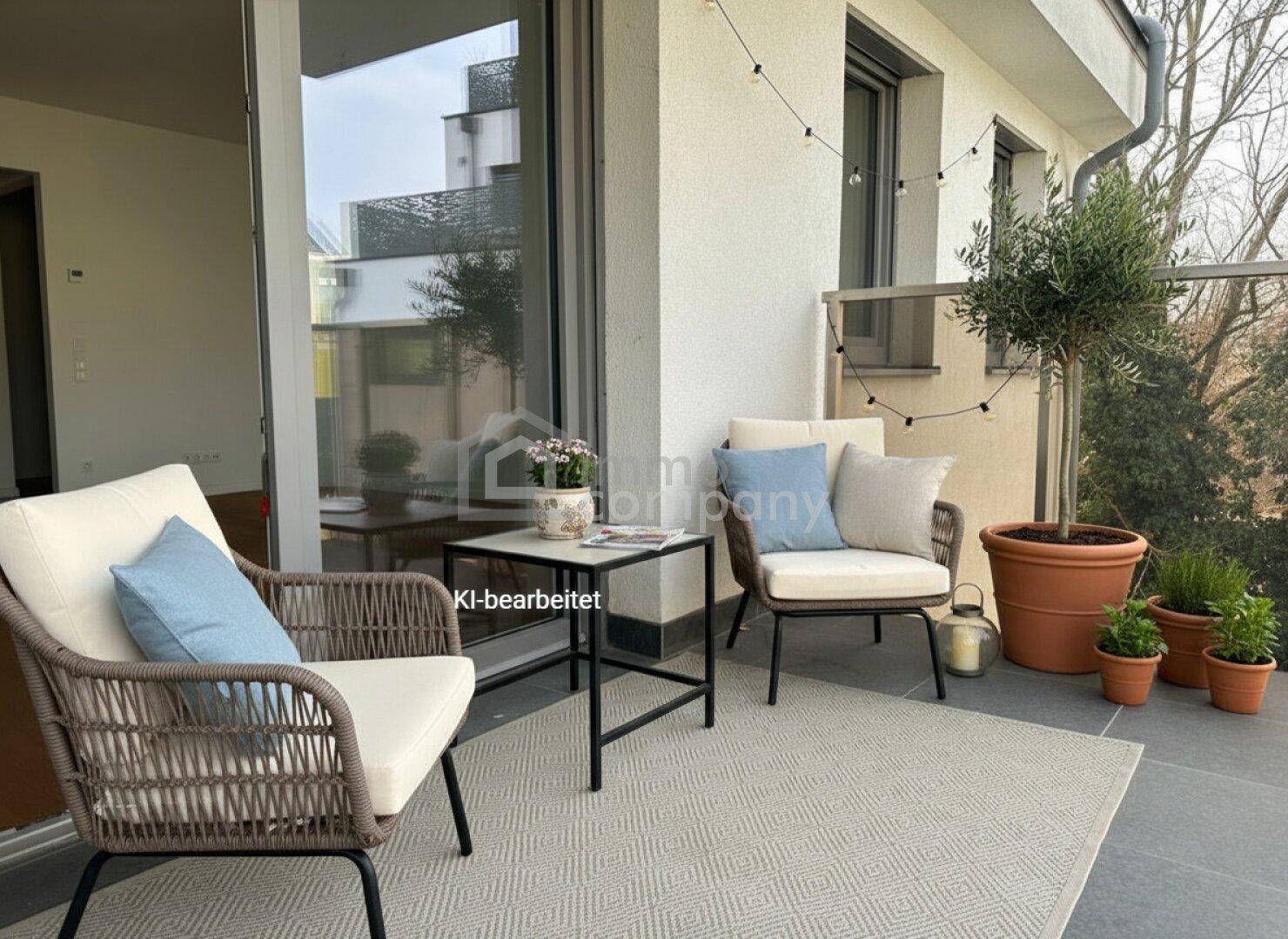 Attraktiver Balkon mit bequemen Sitzgelegenheiten, Pflanzen und Blick ins Grüne.