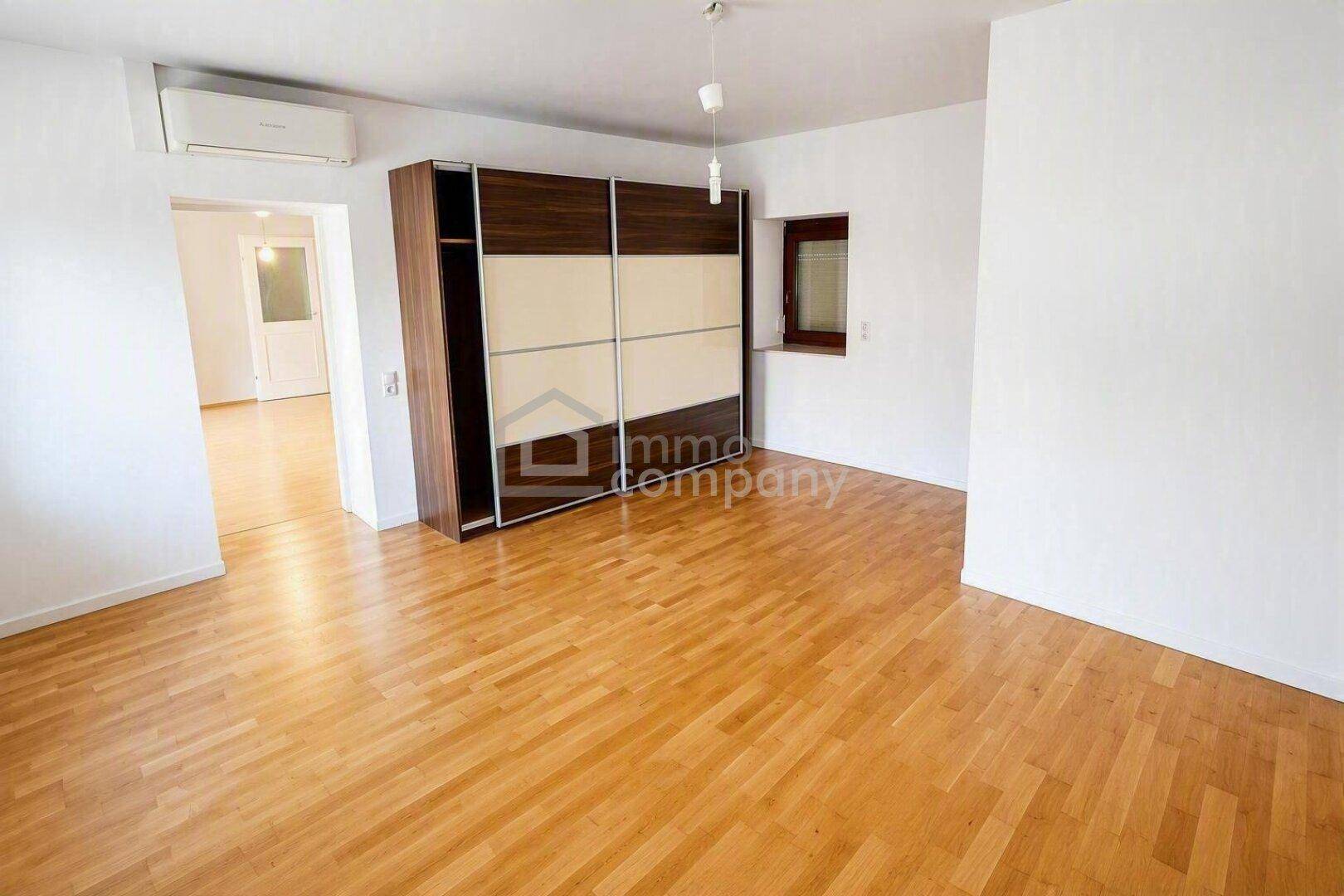 Geräumiges Zimmer mit Parkettboden, Einbauschrank und Klimaanlage, bietet vielseitige Nutzungsmöglichkeiten.