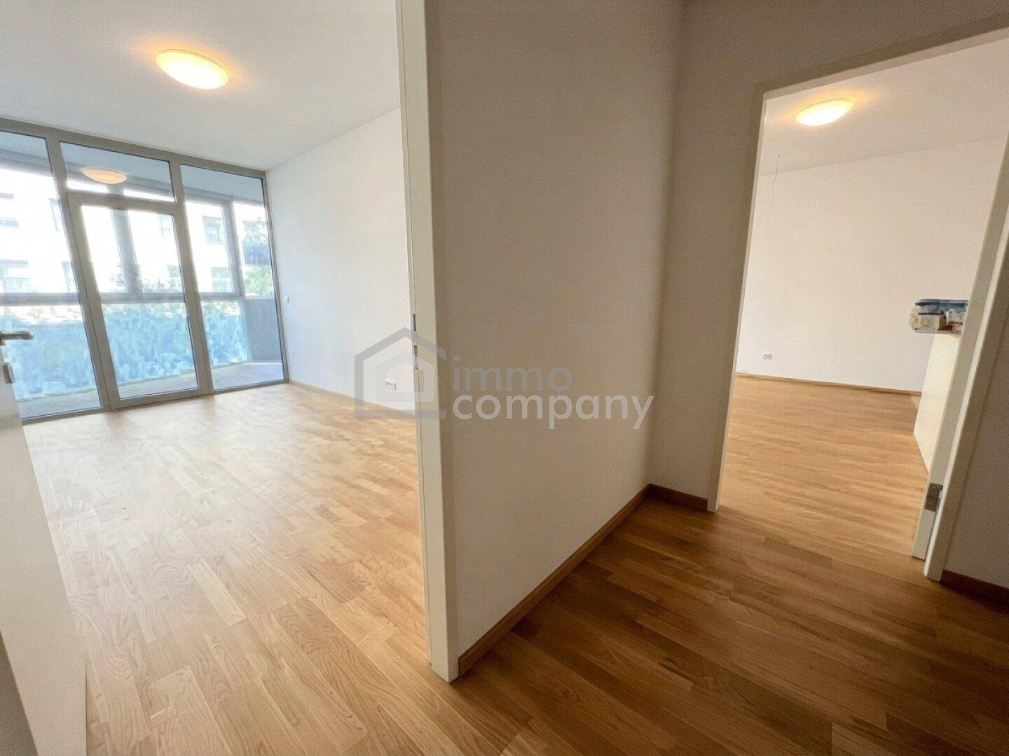 Heller Raum mit Parkettboden und großen Fenstern, der viel natürliches Licht erhält.