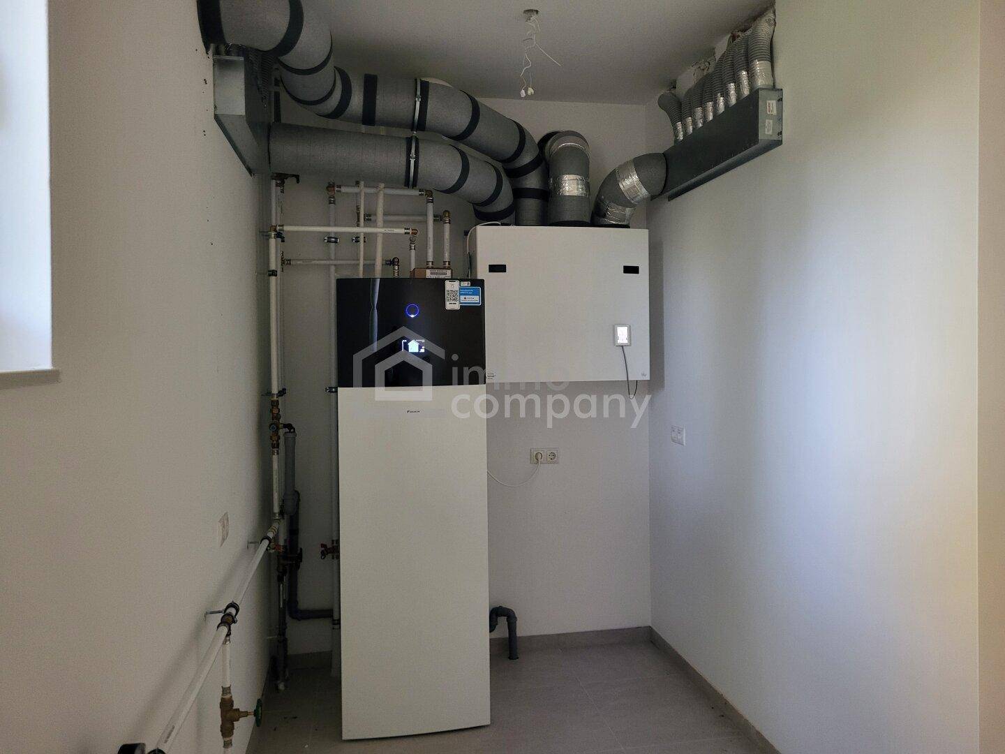 Technikraum mit moderner Wärmepumpe und Lüftungsanlage für effiziente Haustechnik.