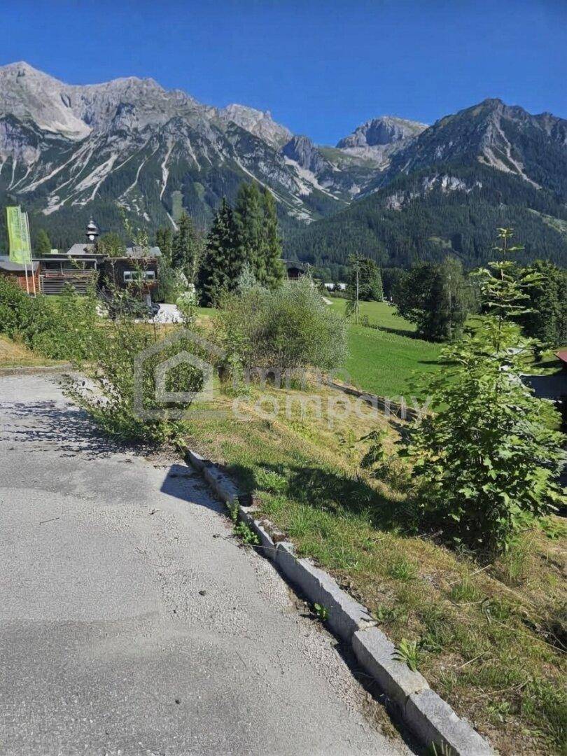 Weitläufige Berglandschaft mit üppigem Grün und einer asphaltierten Straße, die sich durch die Natur schlängelt.