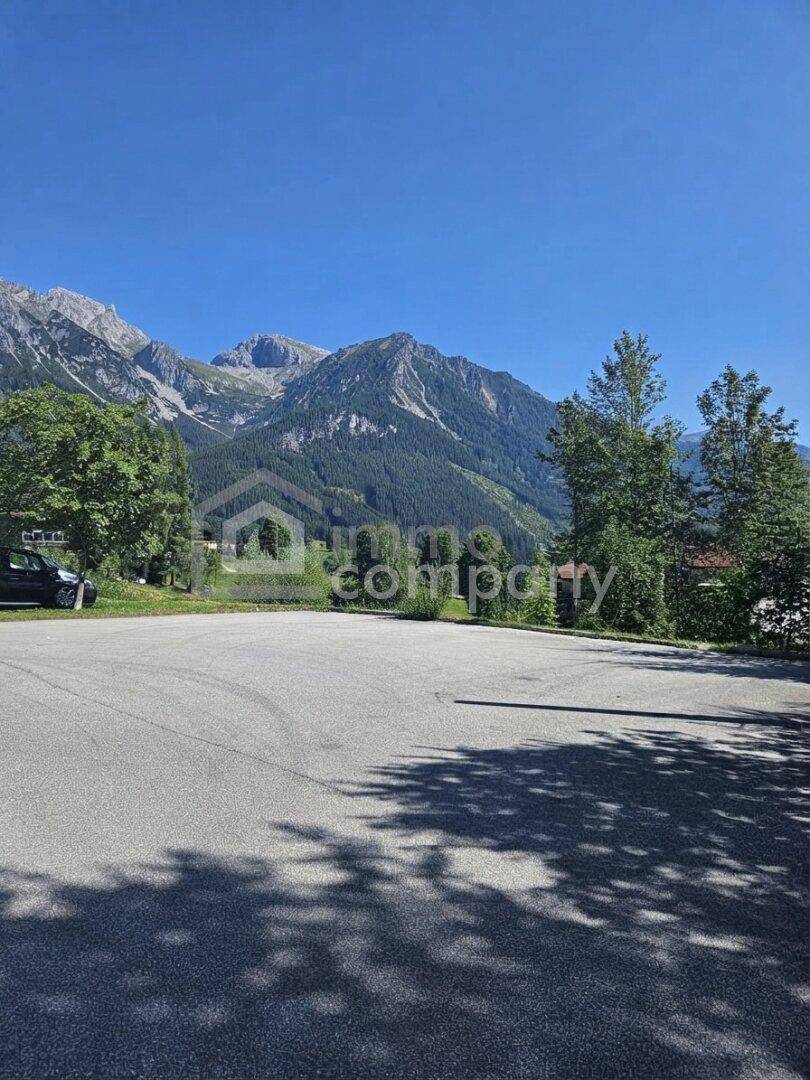 Offener Parkplatz mit beeindruckendem Blick auf die umliegenden Berge und den klaren blauen Himmel.