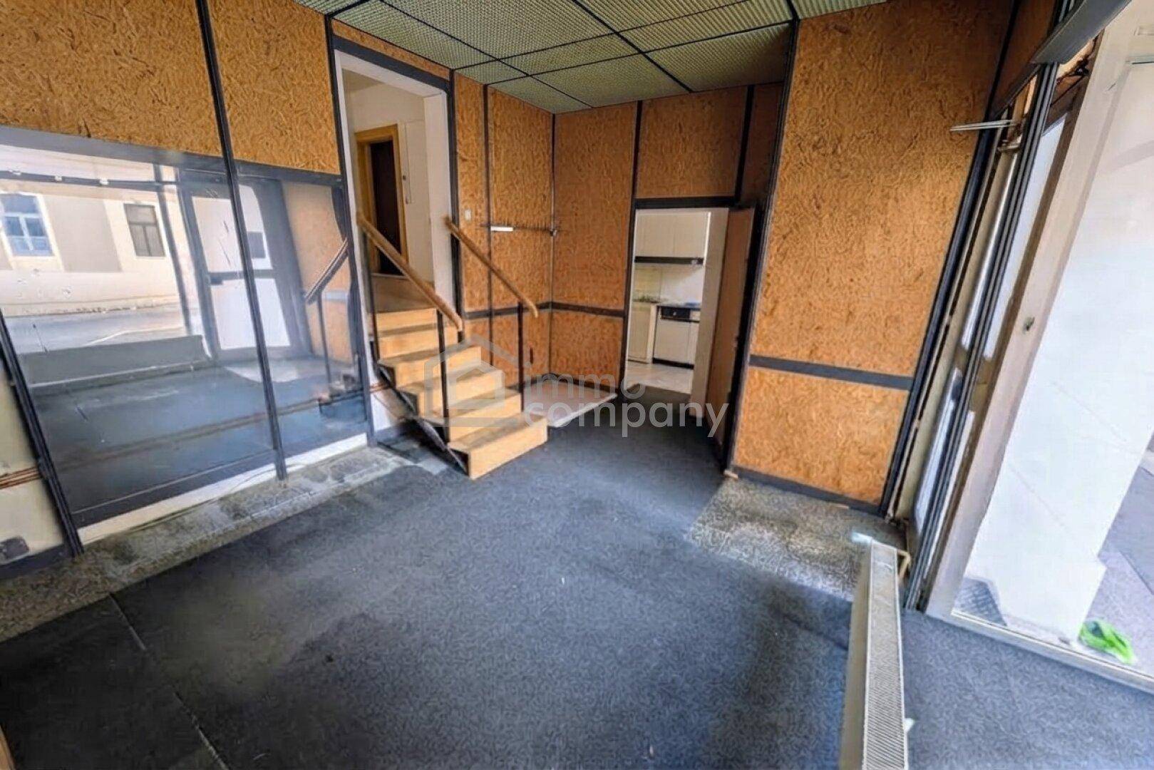 Geräumiger Flur mit Holztreppe und Wänden aus OSB-Platten, führt zu weiteren Räumen.