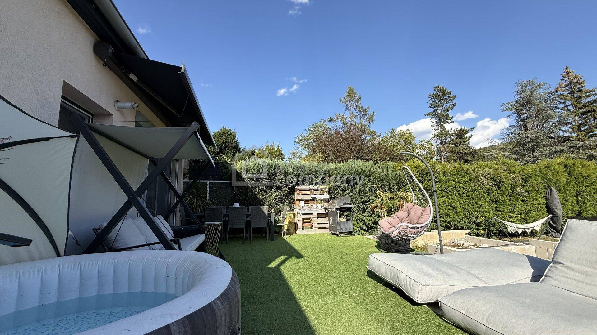 Sonniger Gartenbereich mit aufblasbarem Whirlpool, Liegemöbeln und Grillplatz für Entspannung.