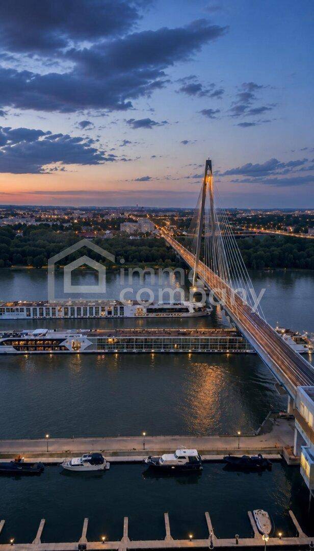 Beeindruckende Nachtansicht einer beleuchteten Brücke über dem Fluss mit Stadtlichtern im Hintergrund.
