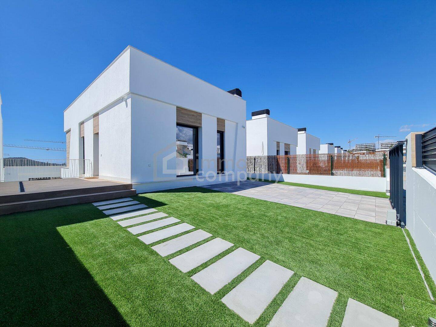 Moderne Architektur mit klaren Linien, kleiner Rasenfläche und Trittsteinen im Außenbereich.
