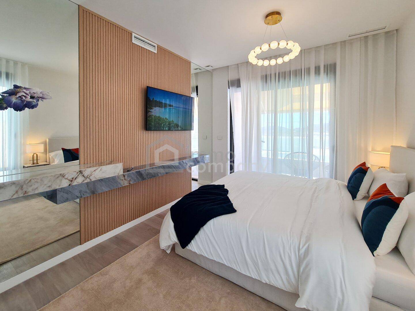 Stilvolles Schlafzimmer mit großem Bett, Spiegelwand und modernem Design.