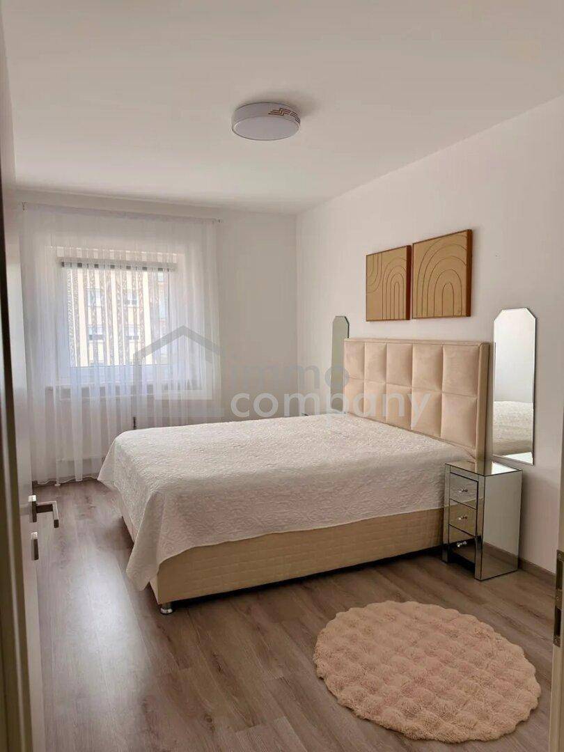 Gemütliches Schlafzimmer mit Doppelbett, Nachttischen und Laminatboden.