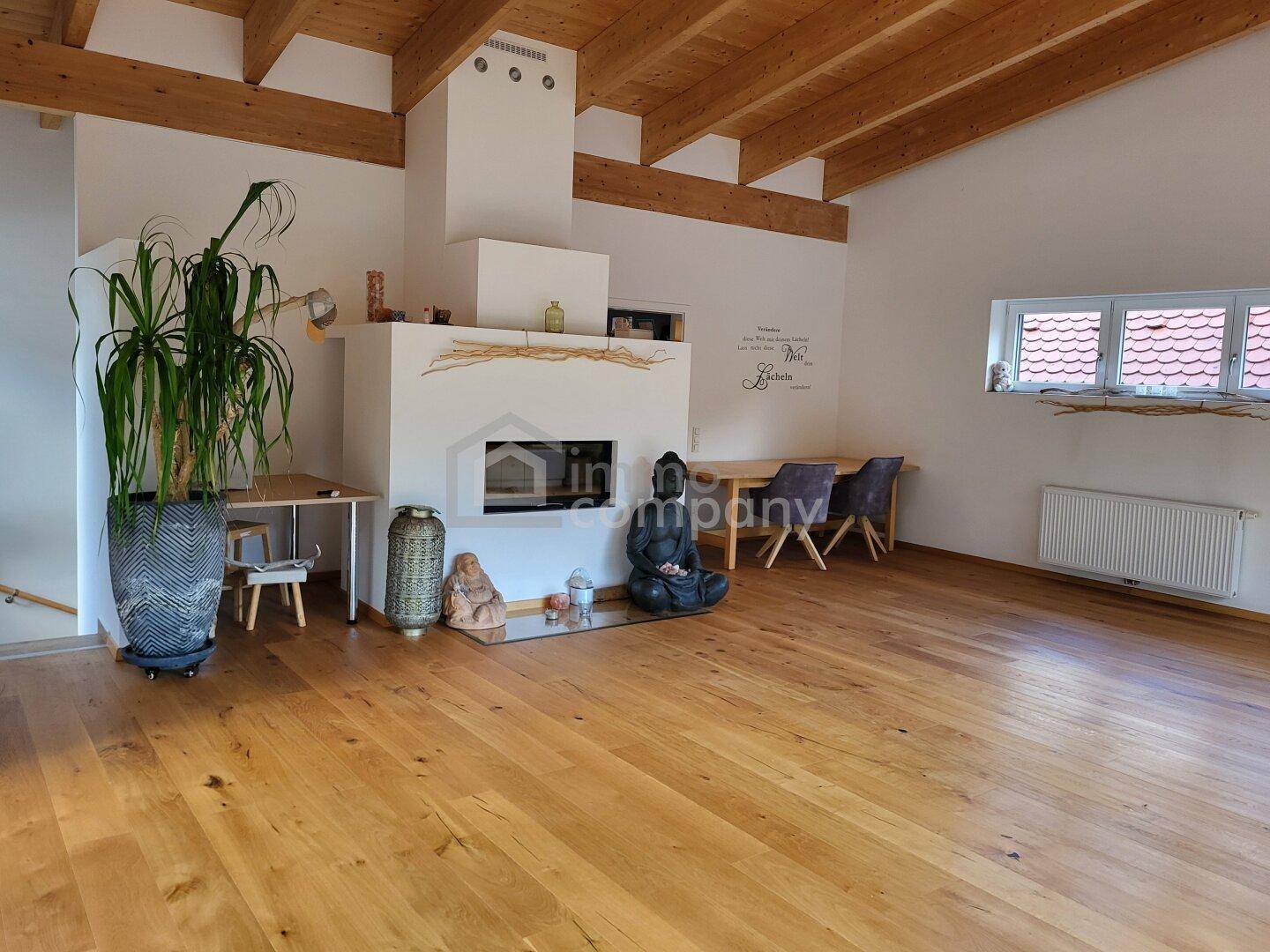 Geräumiger Wohn-Essbereich mit Holzbalkendecke, Kamin und hellem Parkettboden.