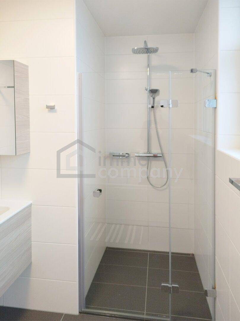 Ebenerdige Dusche mit Glasabtrennung und modernen Fliesen im Badezimmer.