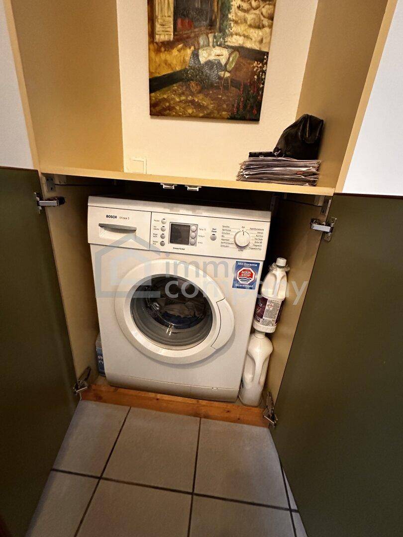 Praktischer Waschmaschinenbereich in einem Schrank integriert, ideal für kleine Wohnungen und Effizienz.