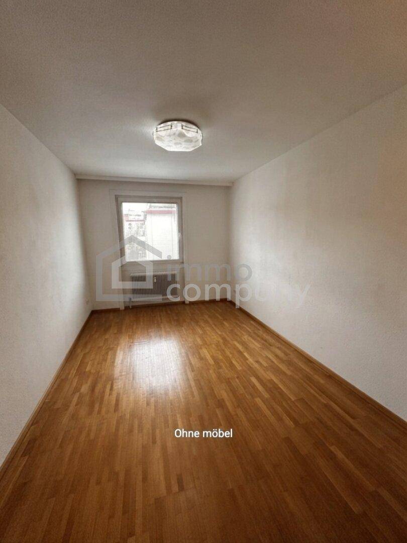Unmöbliertes Zimmer mit Parkettboden und einem Fenster, ideal als Schlaf- oder Arbeitszimmer nutzbar.