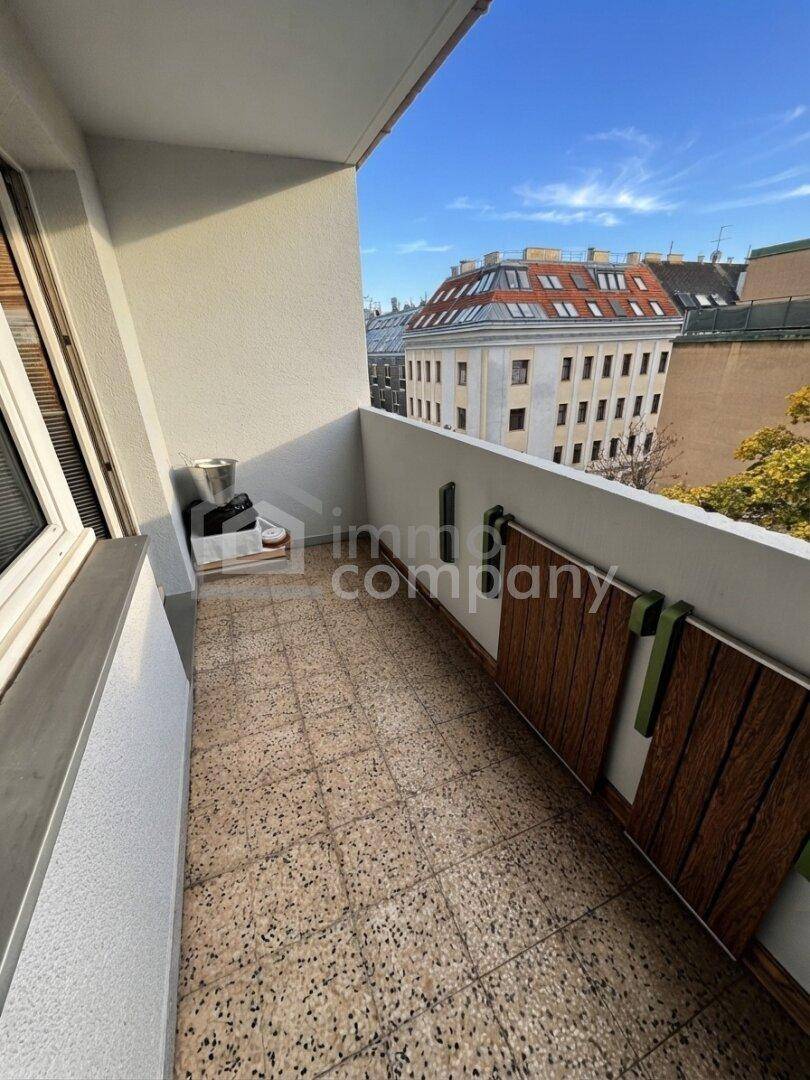Schmaler Balkon mit Fliesenboden und Blick auf die Stadt, ideal für frische Luft und Entspannung.