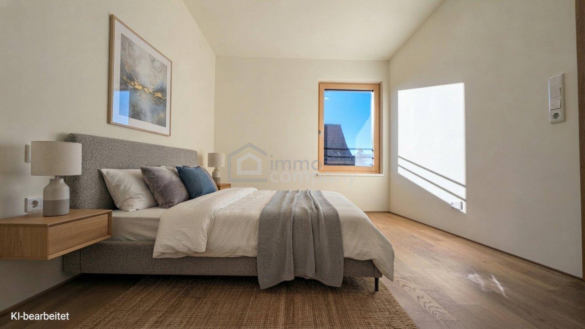 Helles Schlafzimmer mit Holzboden und modernem Bett, durch ein Fenster fällt viel Sonnenlicht herein.