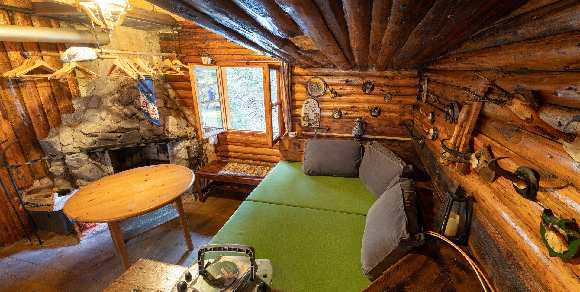 Gemütlicher Schlafbereich mit einem Bett, kleinem Tisch und einem rustikalen Steinkamin.