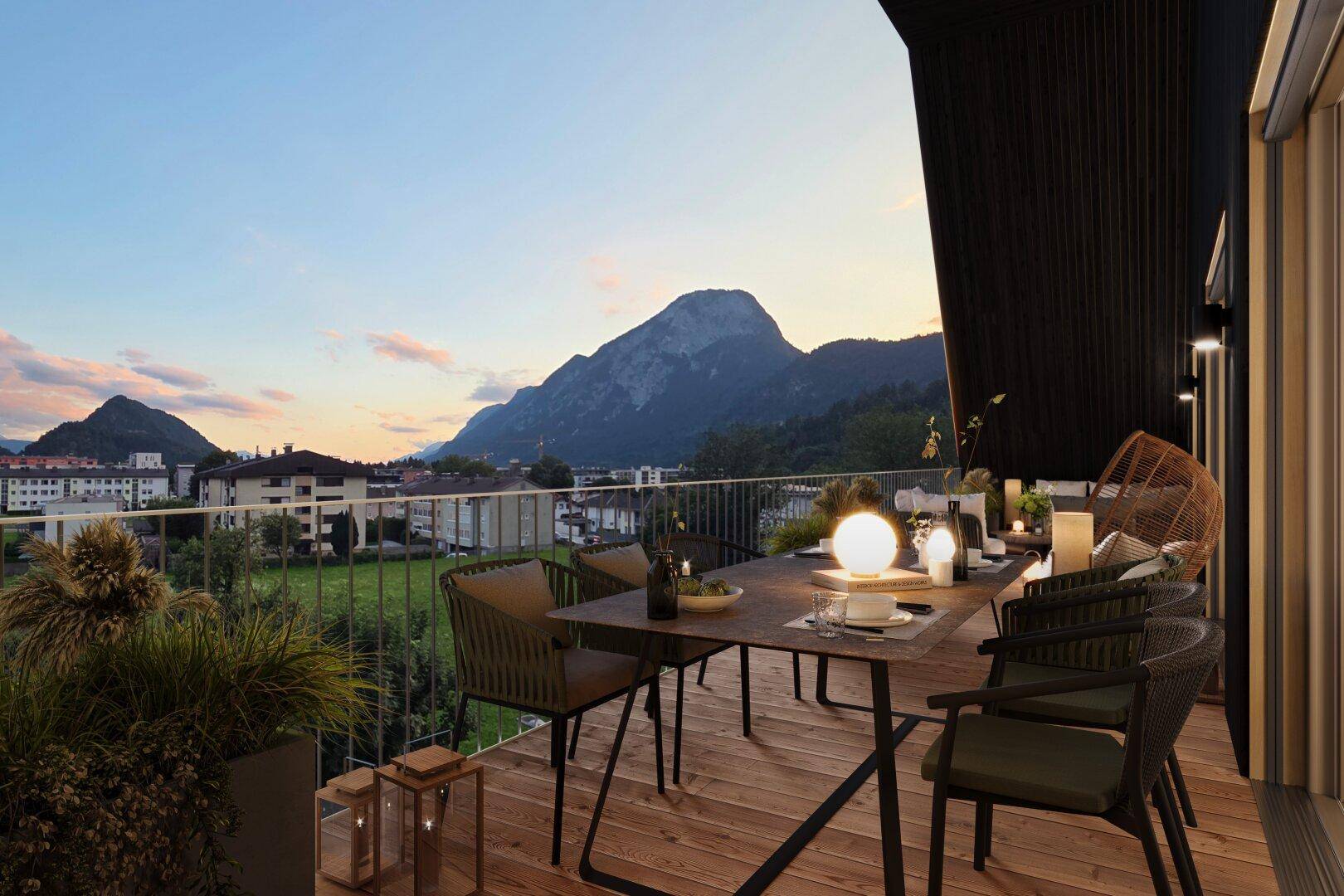 Gemütlicher Balkon mit Esstisch und Stühlen, bietet einen weiten Blick auf die umliegende Berglandschaft.