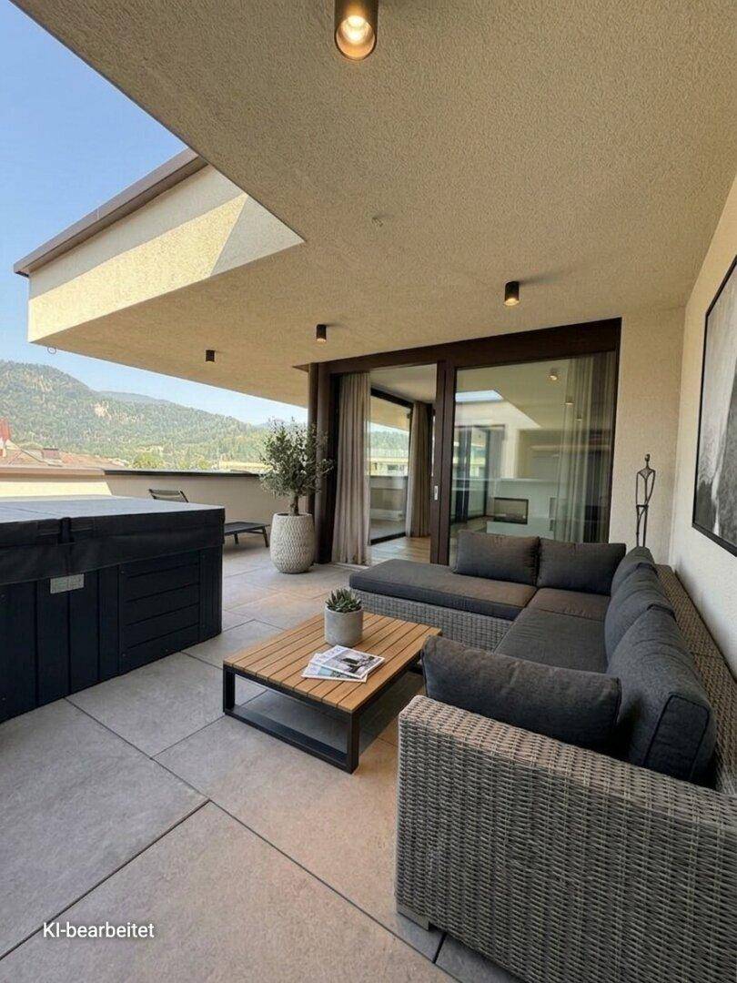 Geräumige Dachterrasse mit moderner Lounge-Möblierung, Whirlpool und weitem Bergblick.