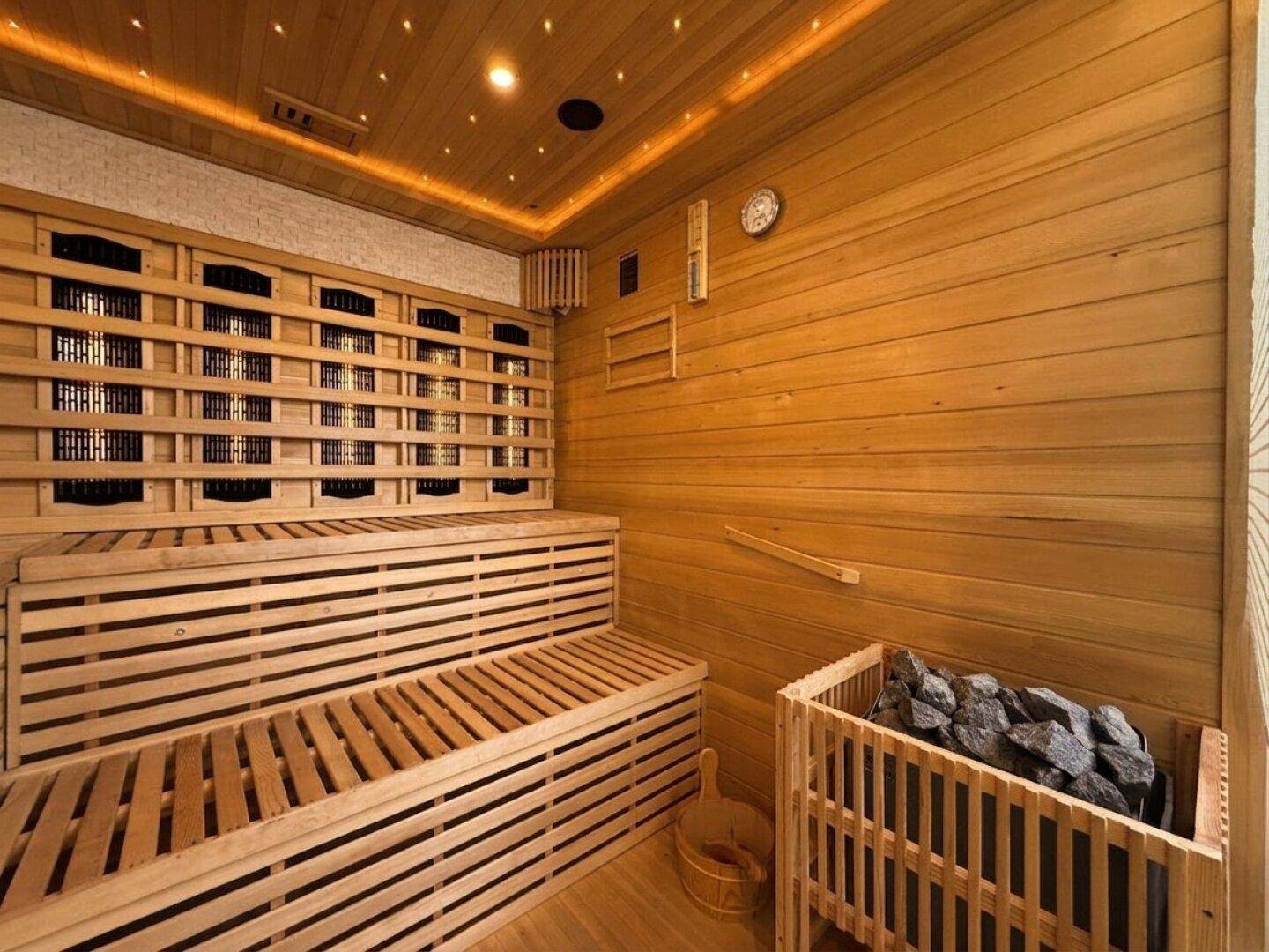 Moderne Holzsauna mit mehreren Bänken, Sternenhimmelbeleuchtung und Saunaofen für Entspannung.